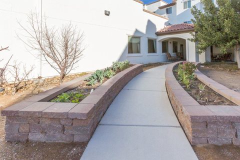 A white house with a grey walkway in front.