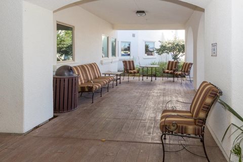 A patio with a striped couch and chairs.