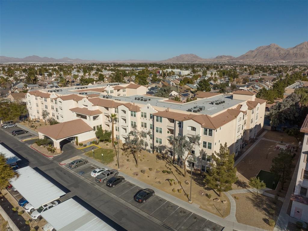 A large apartment complex with a parking lot in front.