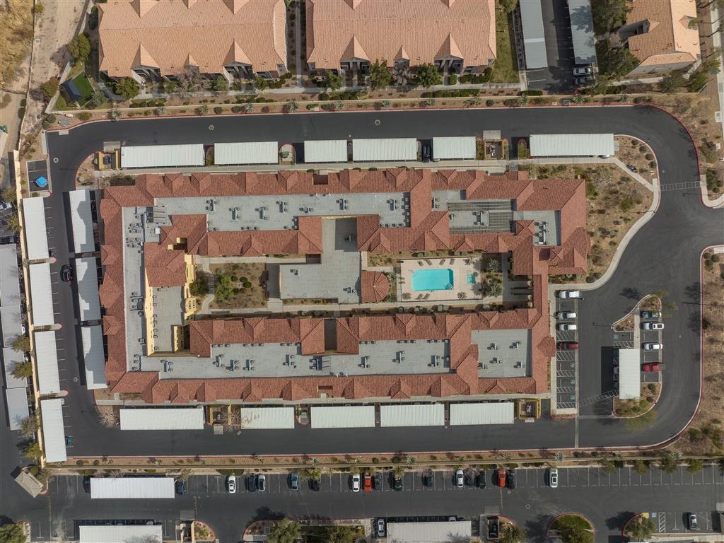 An aerial view of a large building complex with a parking lot in front.