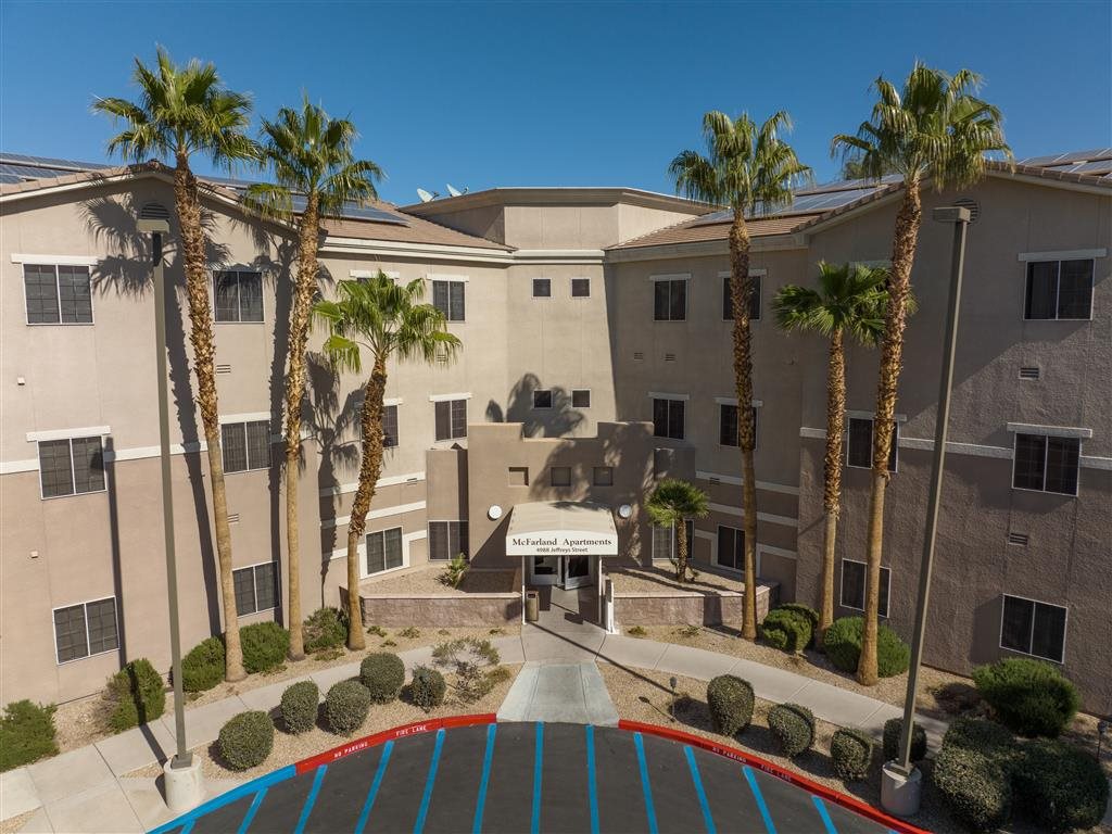 A building with palm trees in front of it.