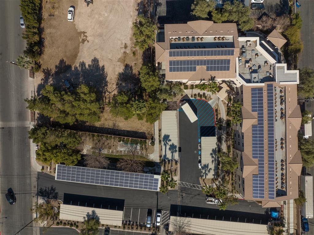 A building with a green roof and solar panels on the side.