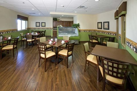 A restaurant with wooden floors and tables set for dining.