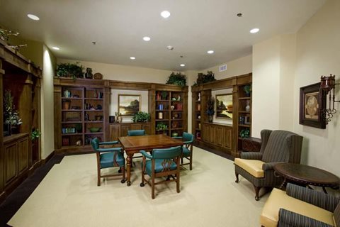 A living room with a wooden table surrounded by chairs.