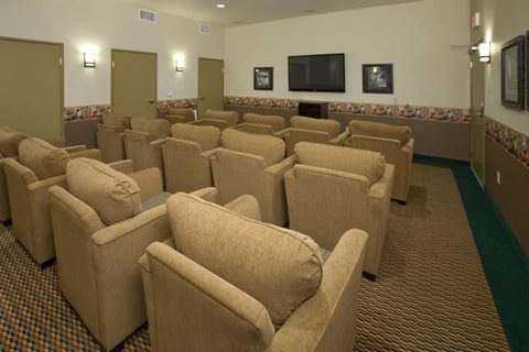 A room with rows of chairs facing a television.