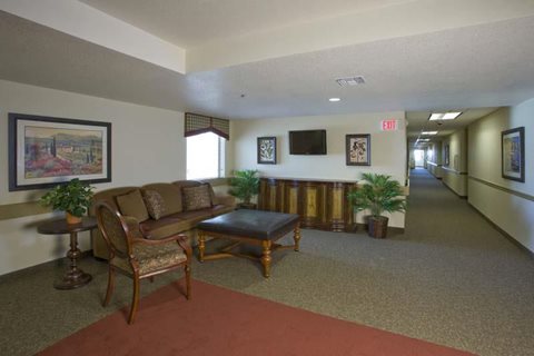 A living room with a couch, chair, and a painting on the wall.