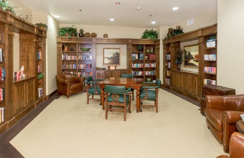A room filled with bookshelves and a table in the middle.