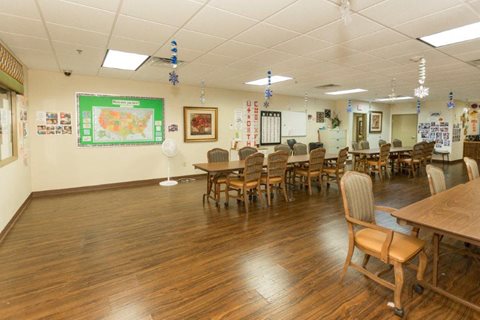 A classroom with wooden floors and tables.