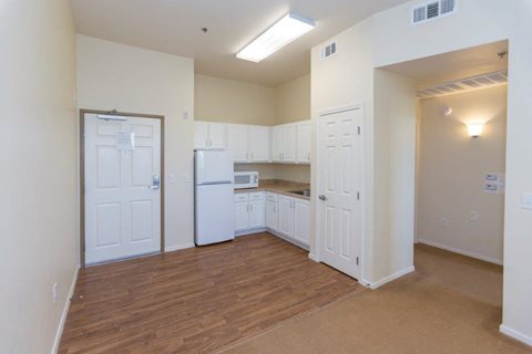 A kitchen with white appliances and cabinets.