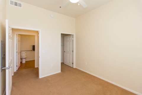 A room with a carpeted floor and two doors.