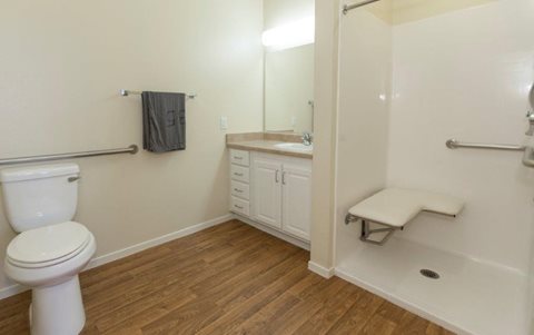 A bathroom with a toilet, sink, and shower.
