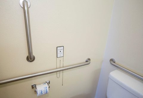 A white toilet paper roll is on a silver towel rack.
