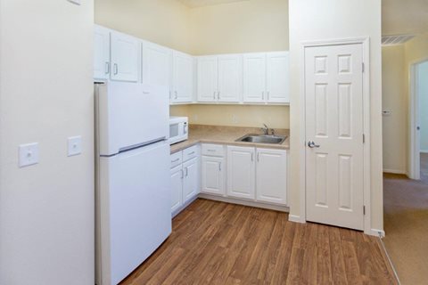A kitchen with white appliances and cabinets.