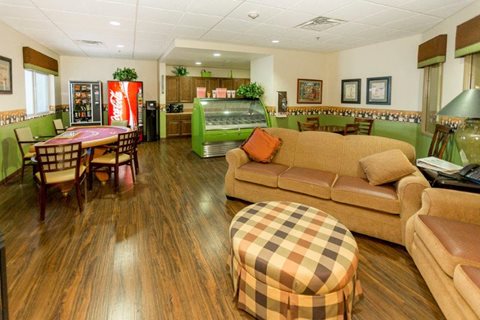 A living room with a brown couch and a wooden floor.