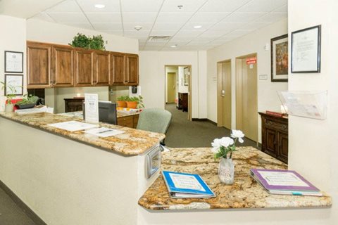 A reception area with a counter and a vase of flowers on it.
