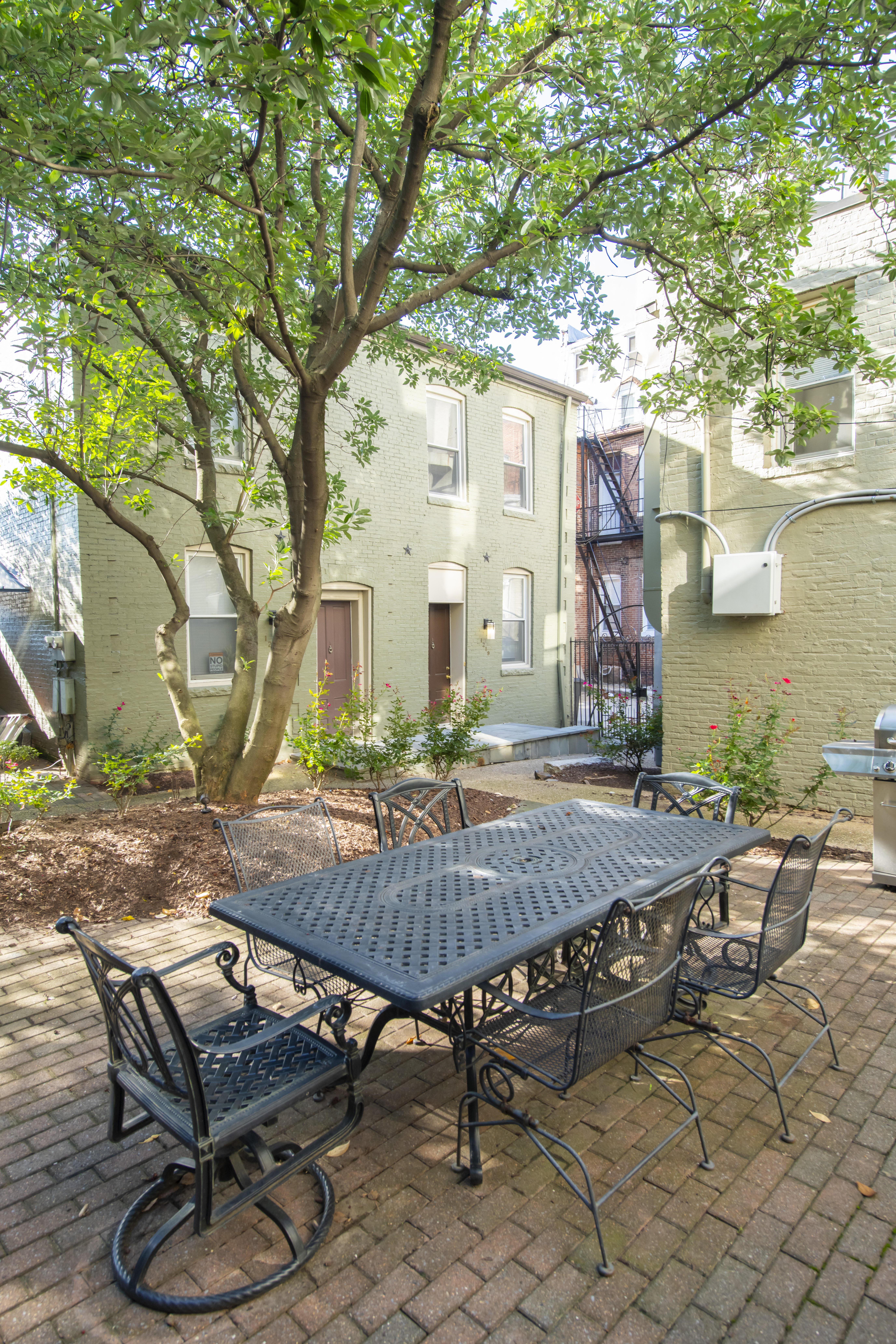 a patio with a table and chairs and a tree at Queen Anne Belvedere, Baltimore