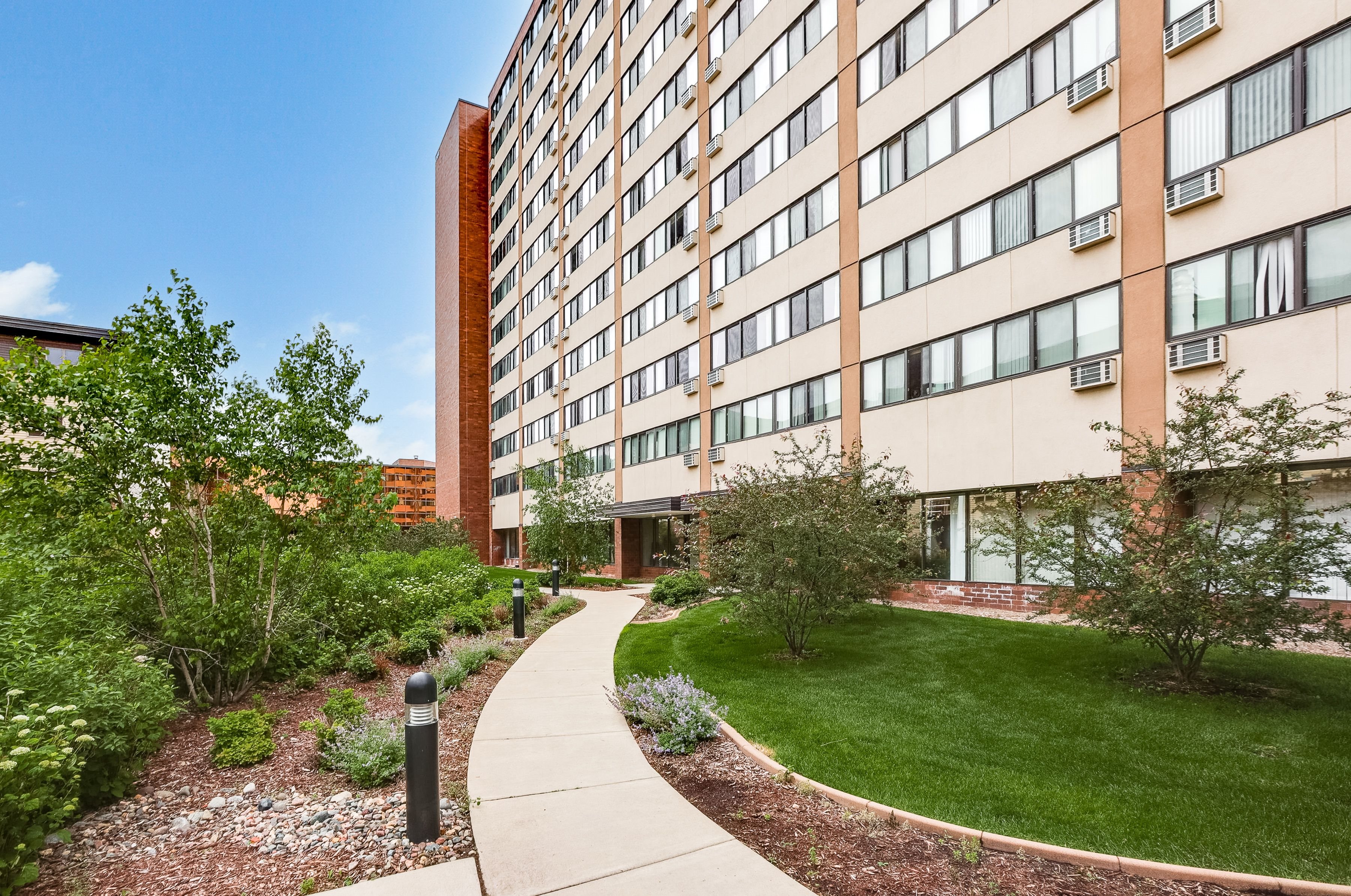 A tall building with a green lawn in front.