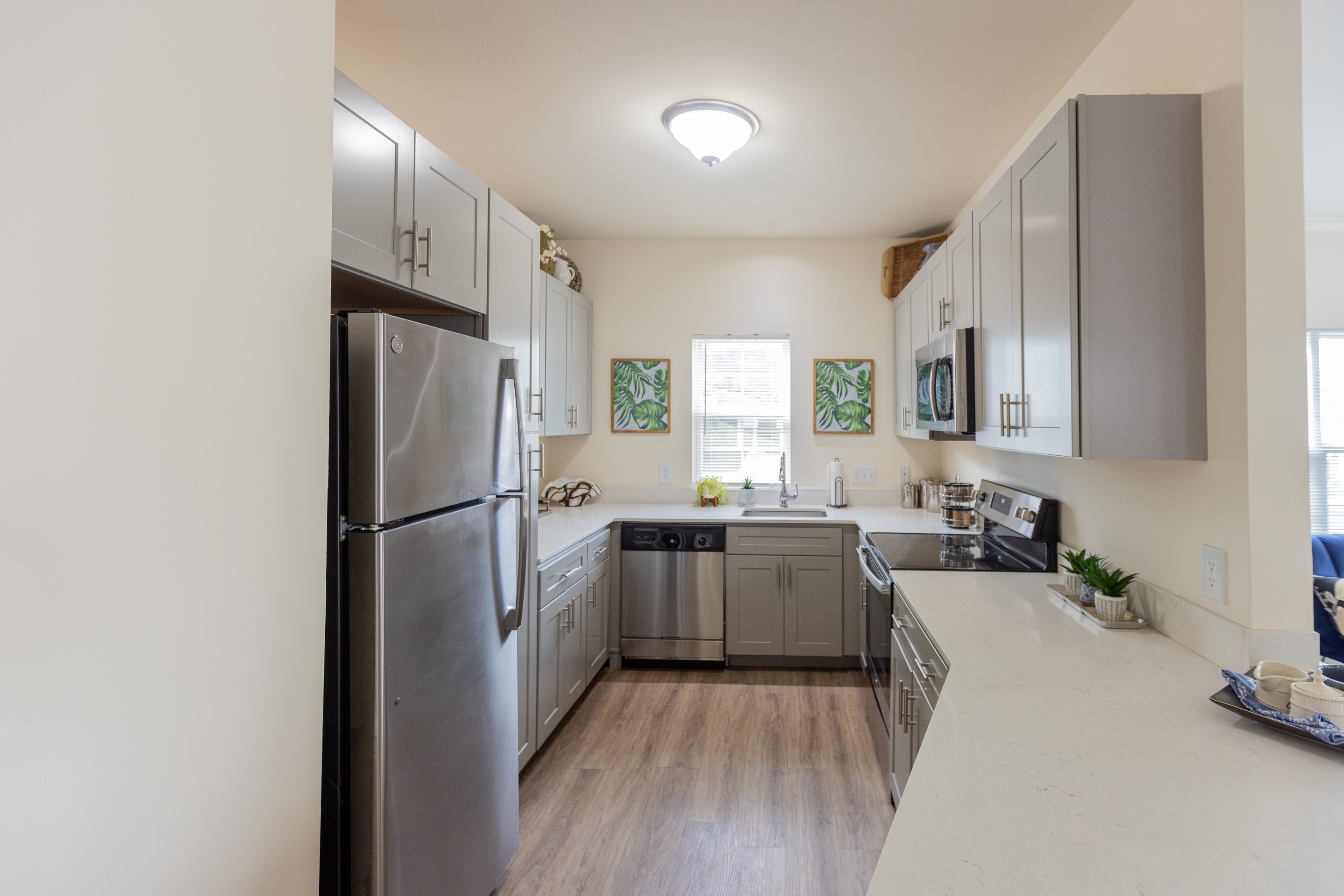 A kitchen with a refrigerator, sink, and cabinets.