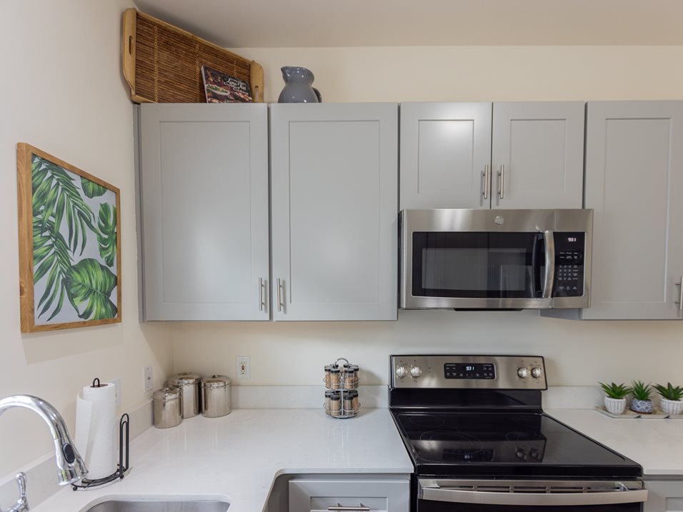 A kitchen with a stove top oven and a microwave above it.