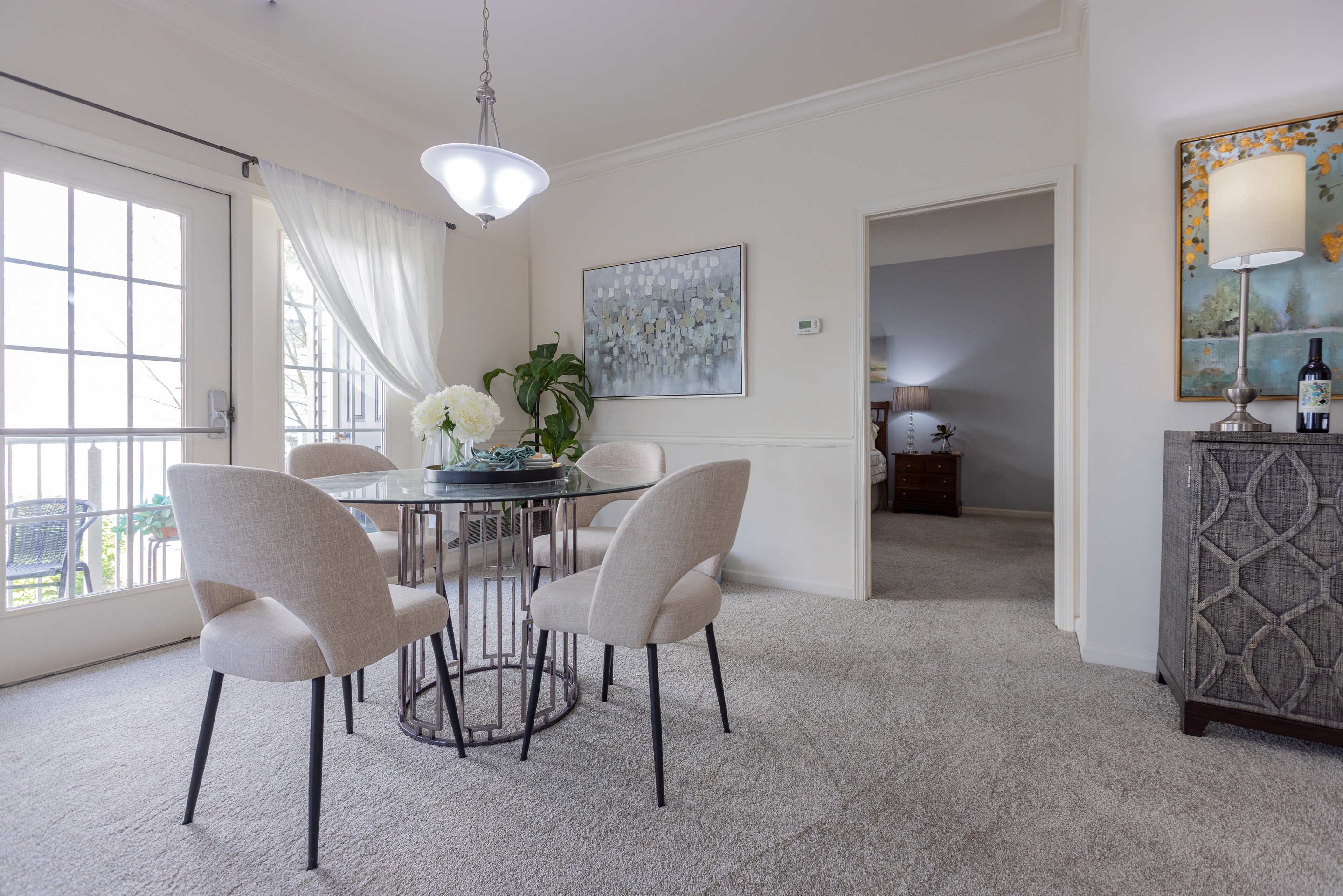 A dining room with a glass table and chairs.