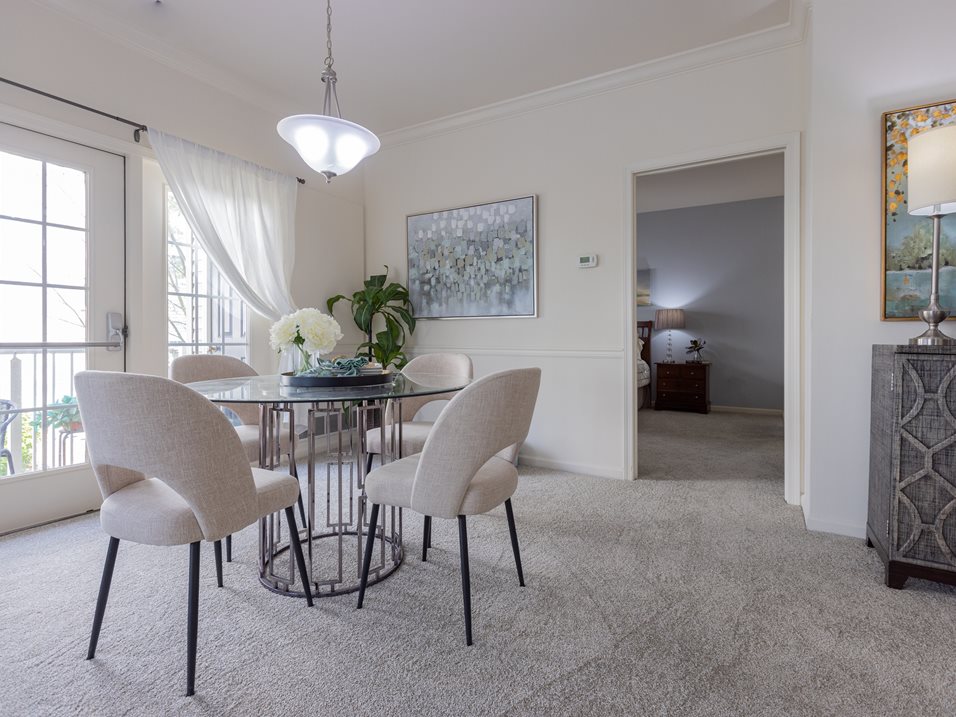 A dining room with a glass table and chairs.