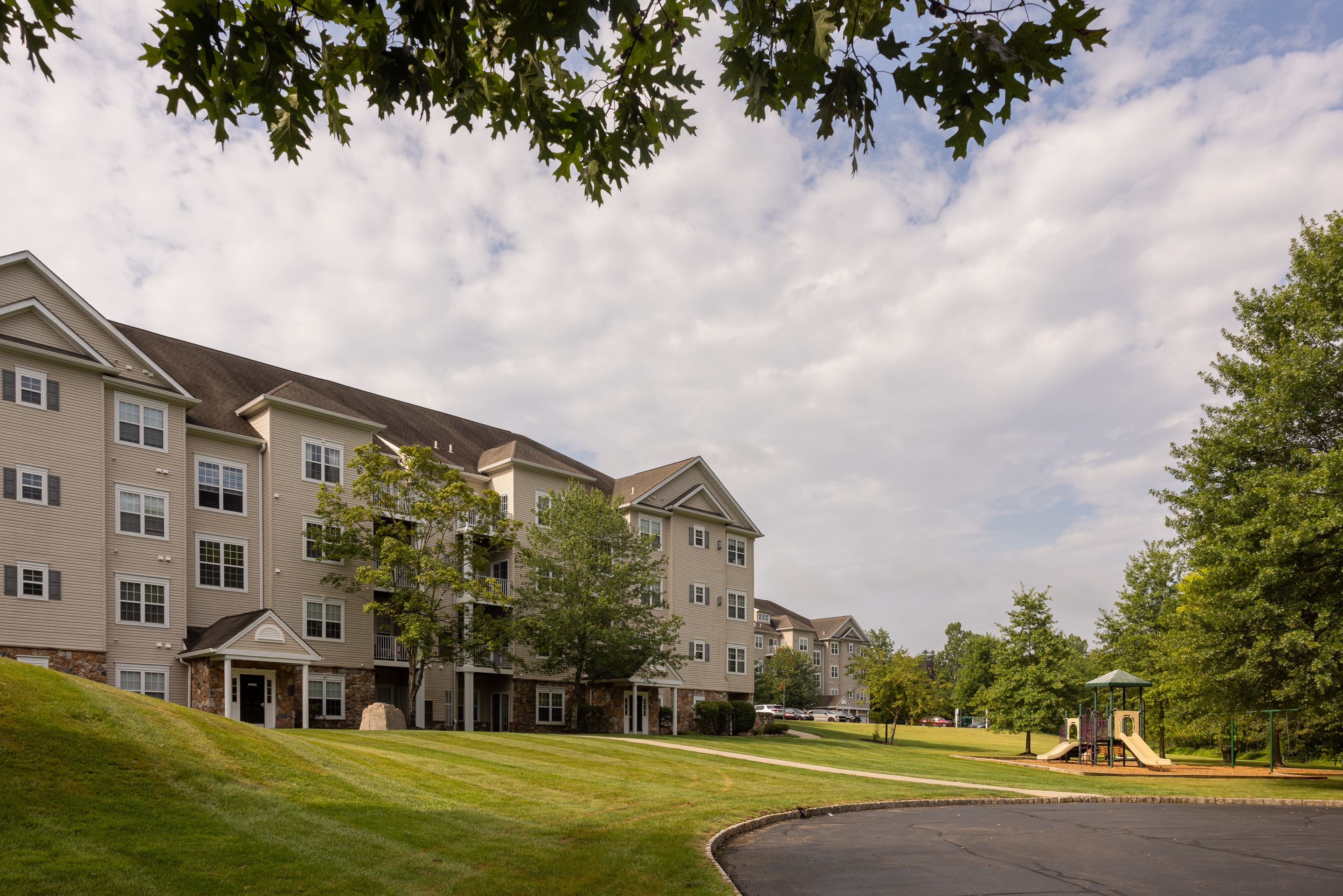 A large apartment complex with a playground in the front.