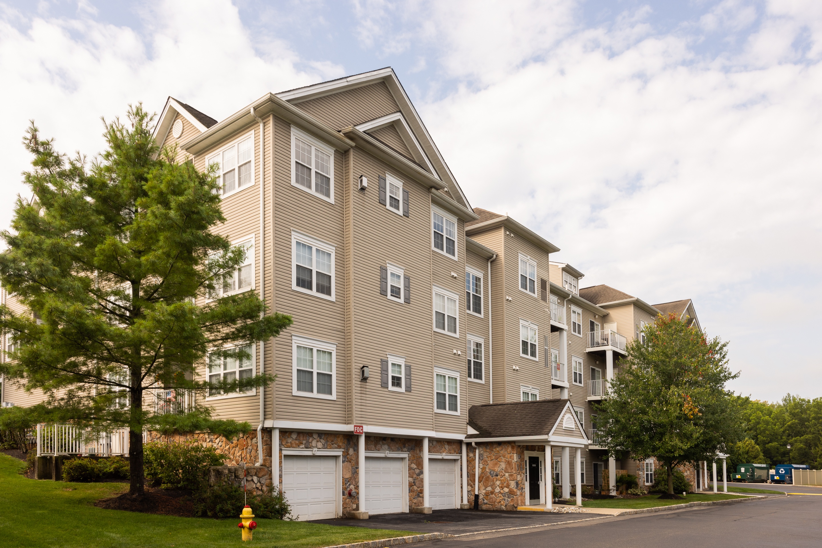 A large apartment building with a parking lot in front.
