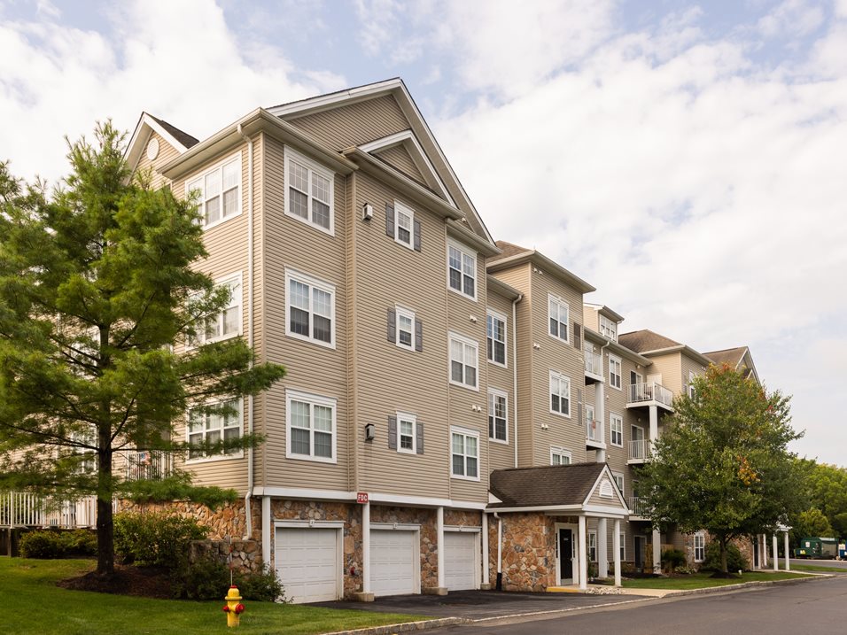 A large apartment building with a parking lot in front.