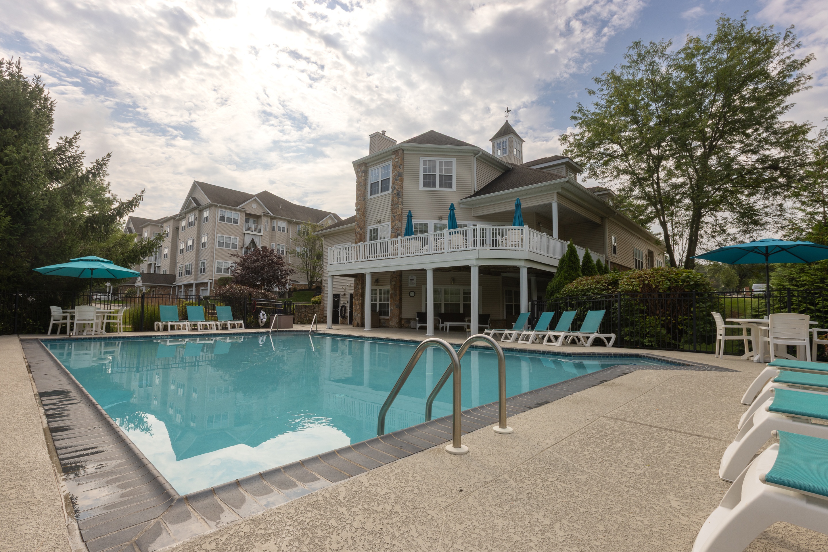 A large swimming pool in front of a resort style building.