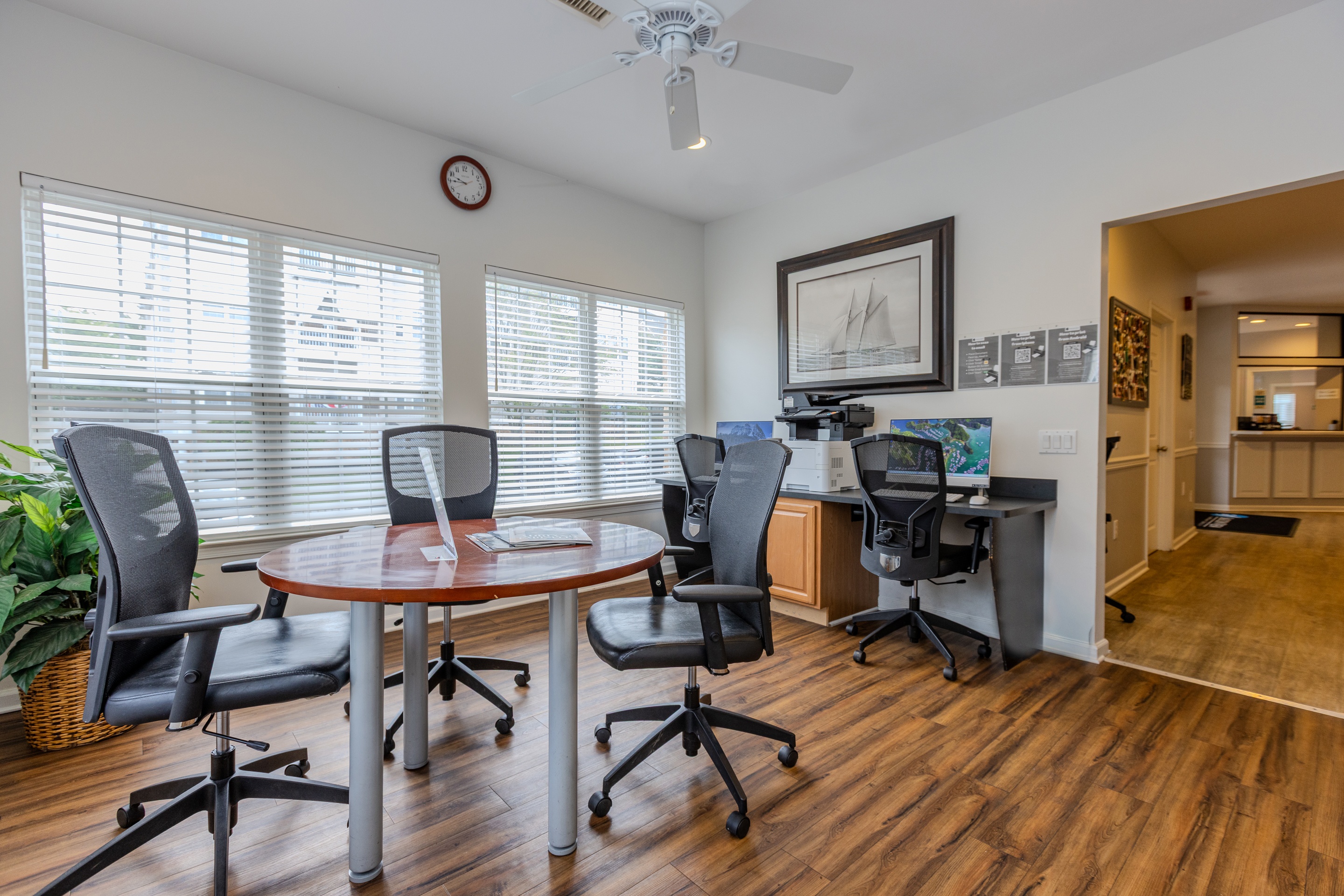 A room with a table and chairs and a fan.