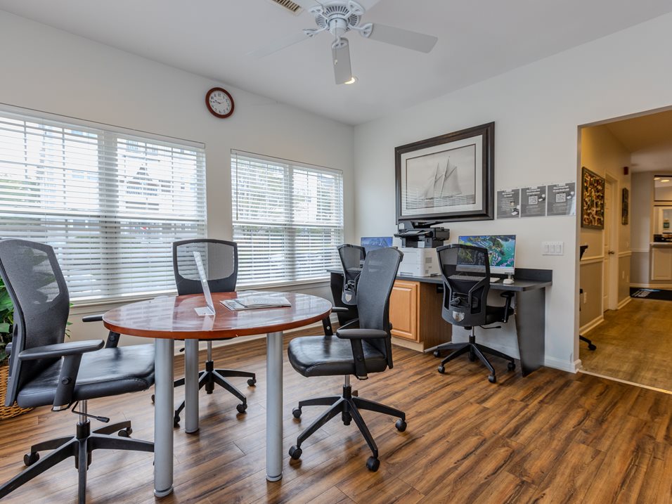 A room with a table and chairs and a fan.