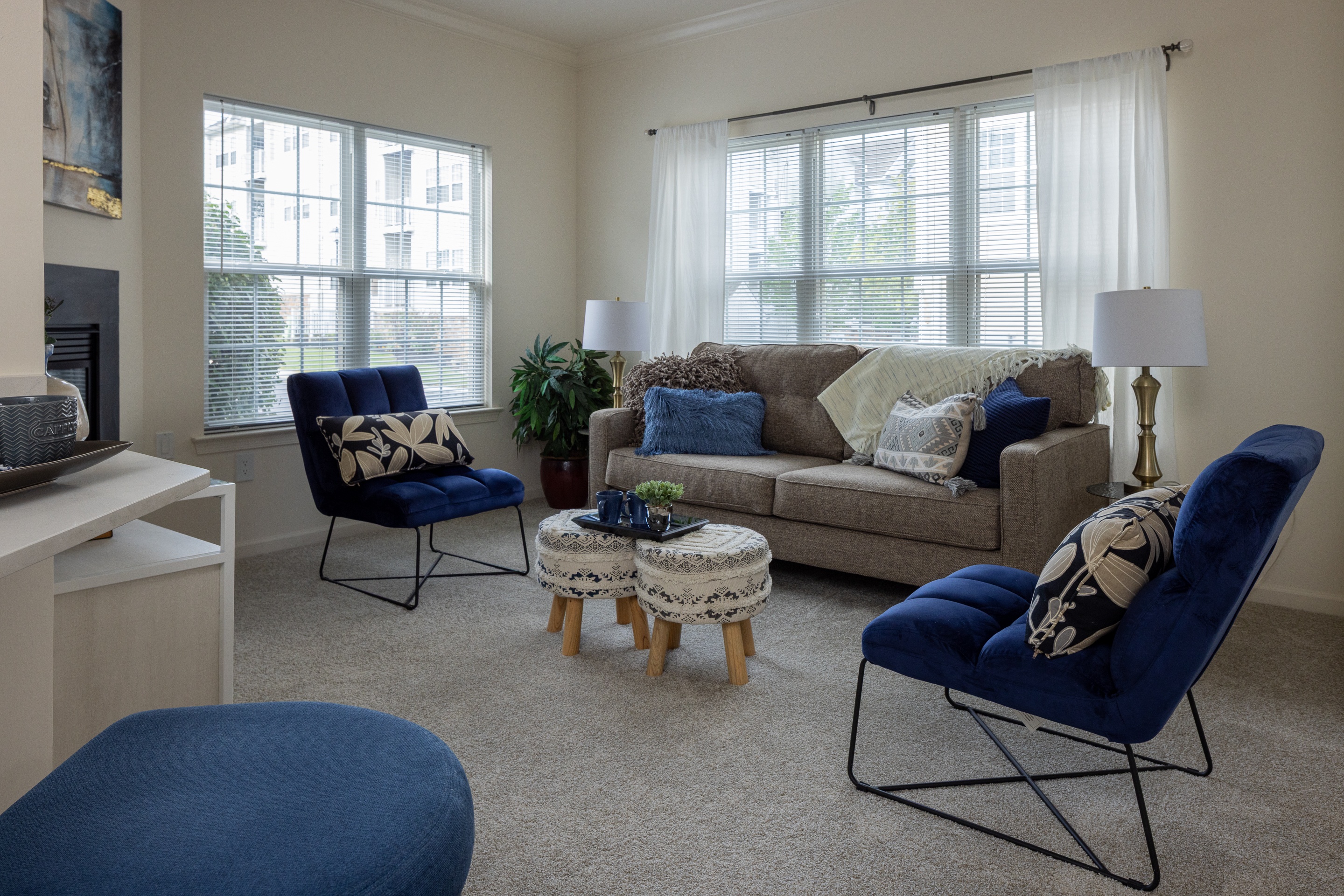 A living room with a grey couch, blue chairs, and a white coffee table.