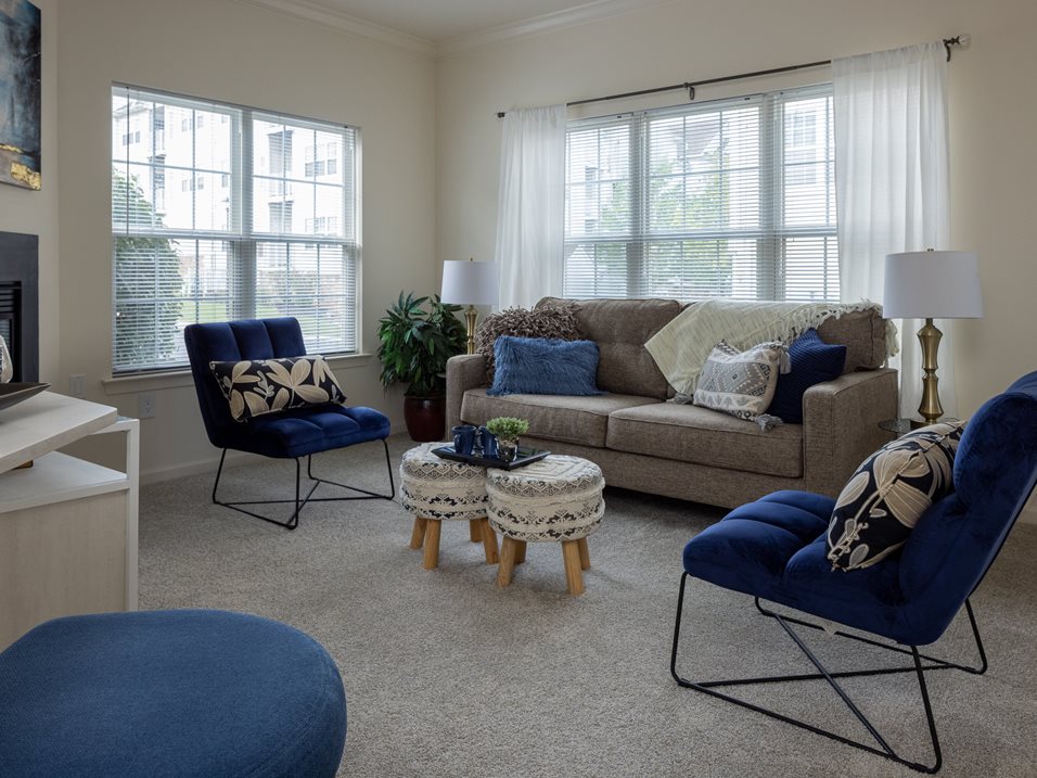 A living room with a grey couch, blue chairs, and a white coffee table.