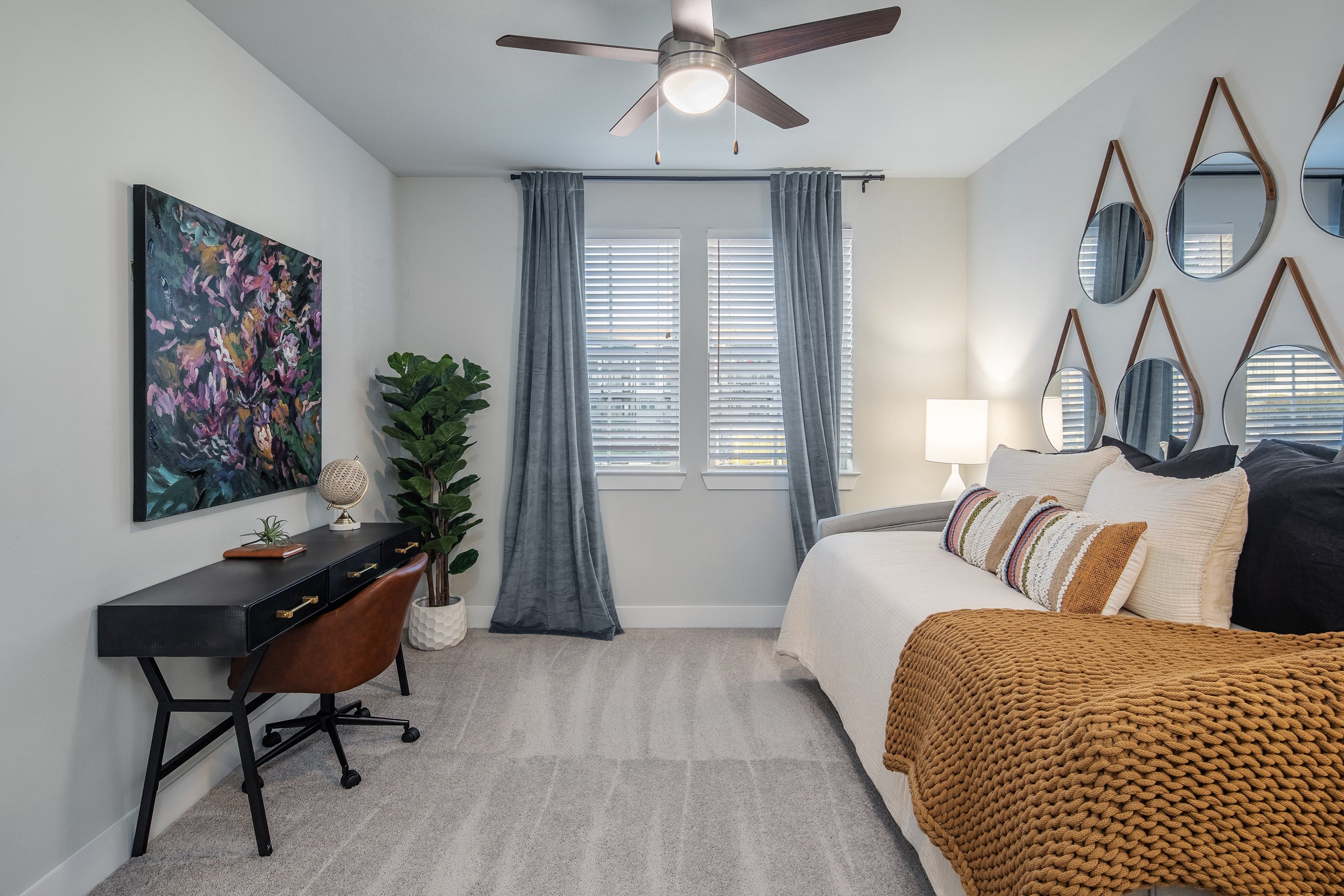 a bedroom with a large bed and a ceiling fan at a senior apartment community