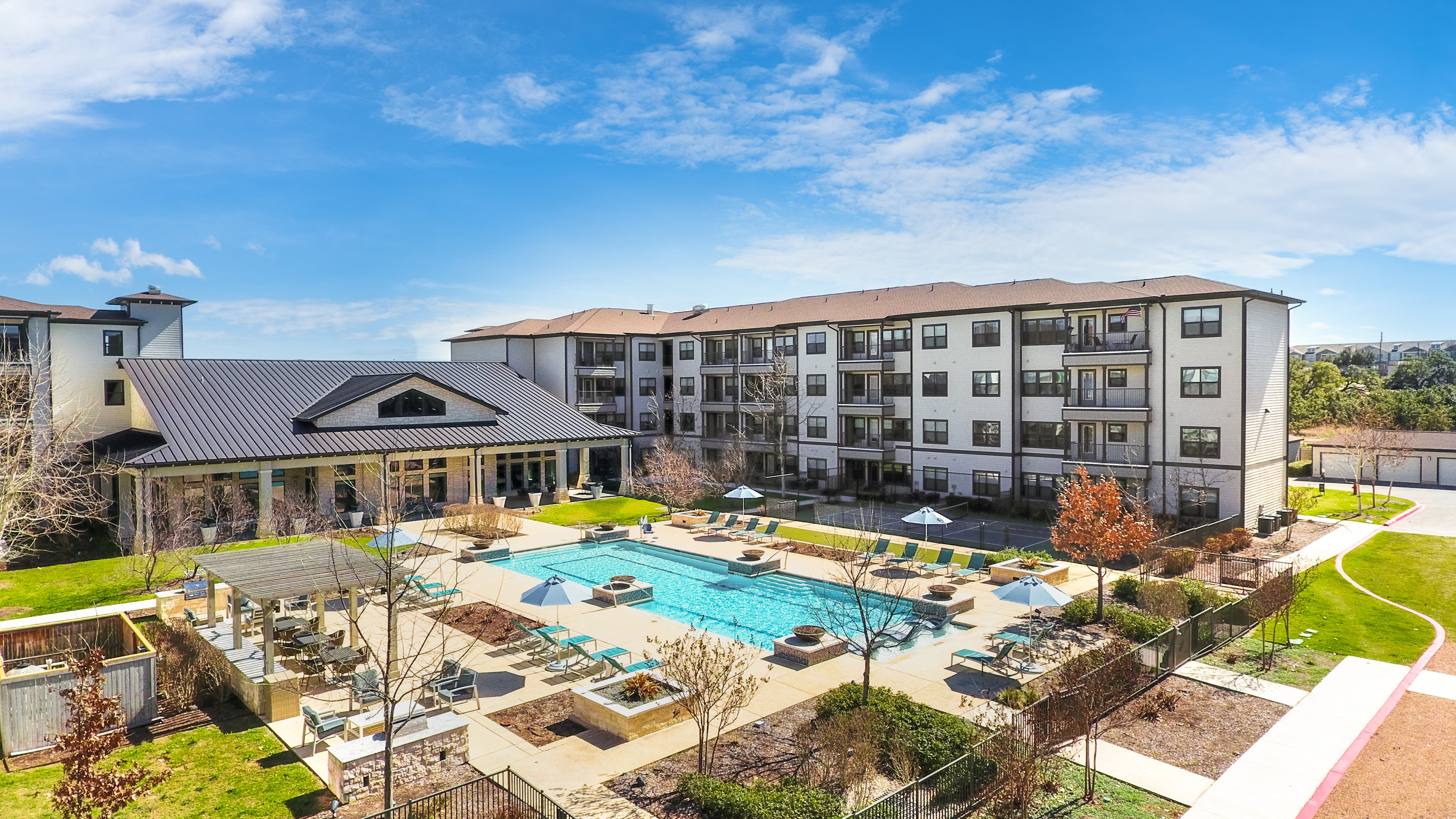 an aerial view of a resort-style pool and courtyard at a senior apartment community