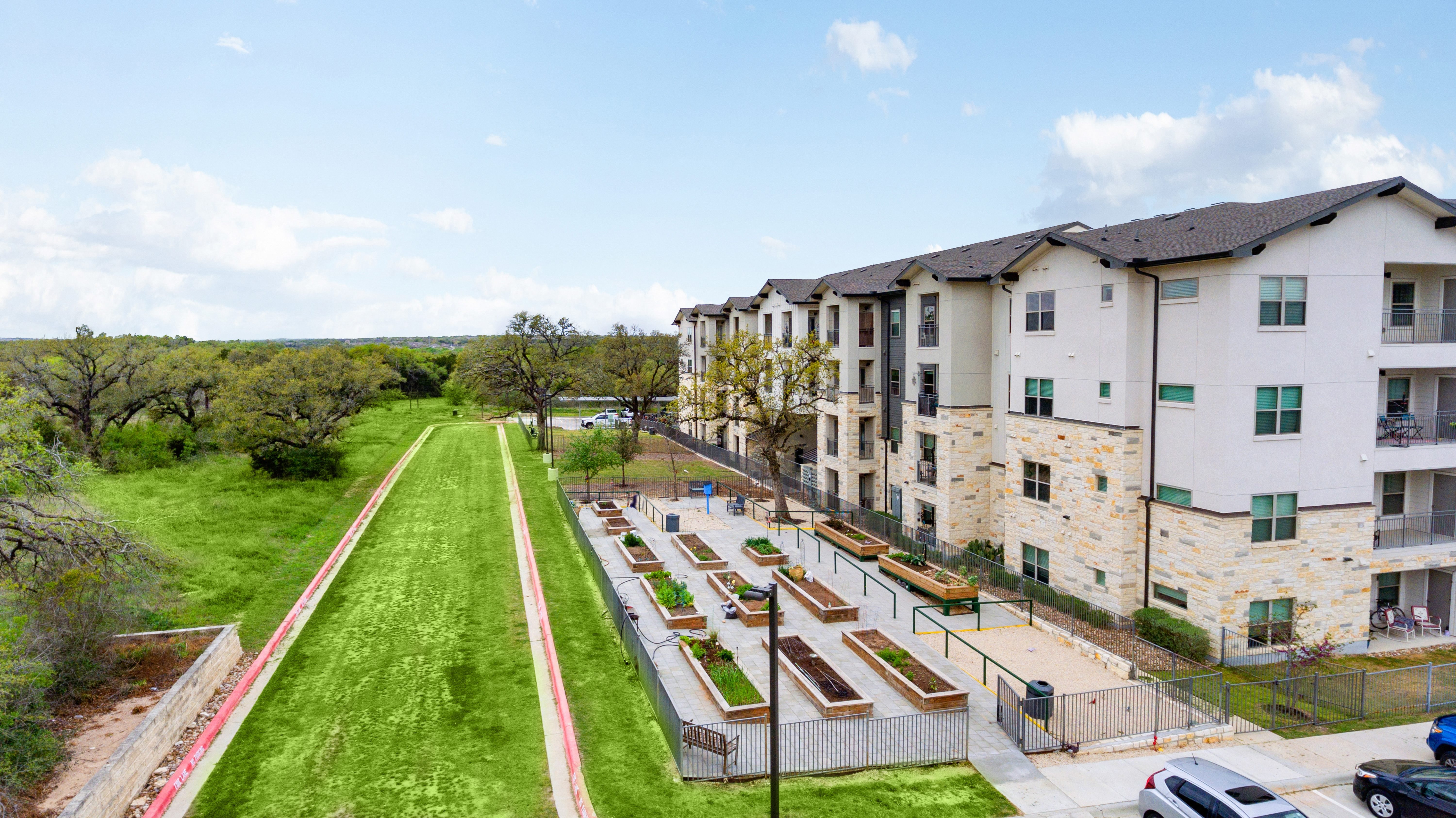 an aerial view of a side yard of raised garden beds at a senior apartment community