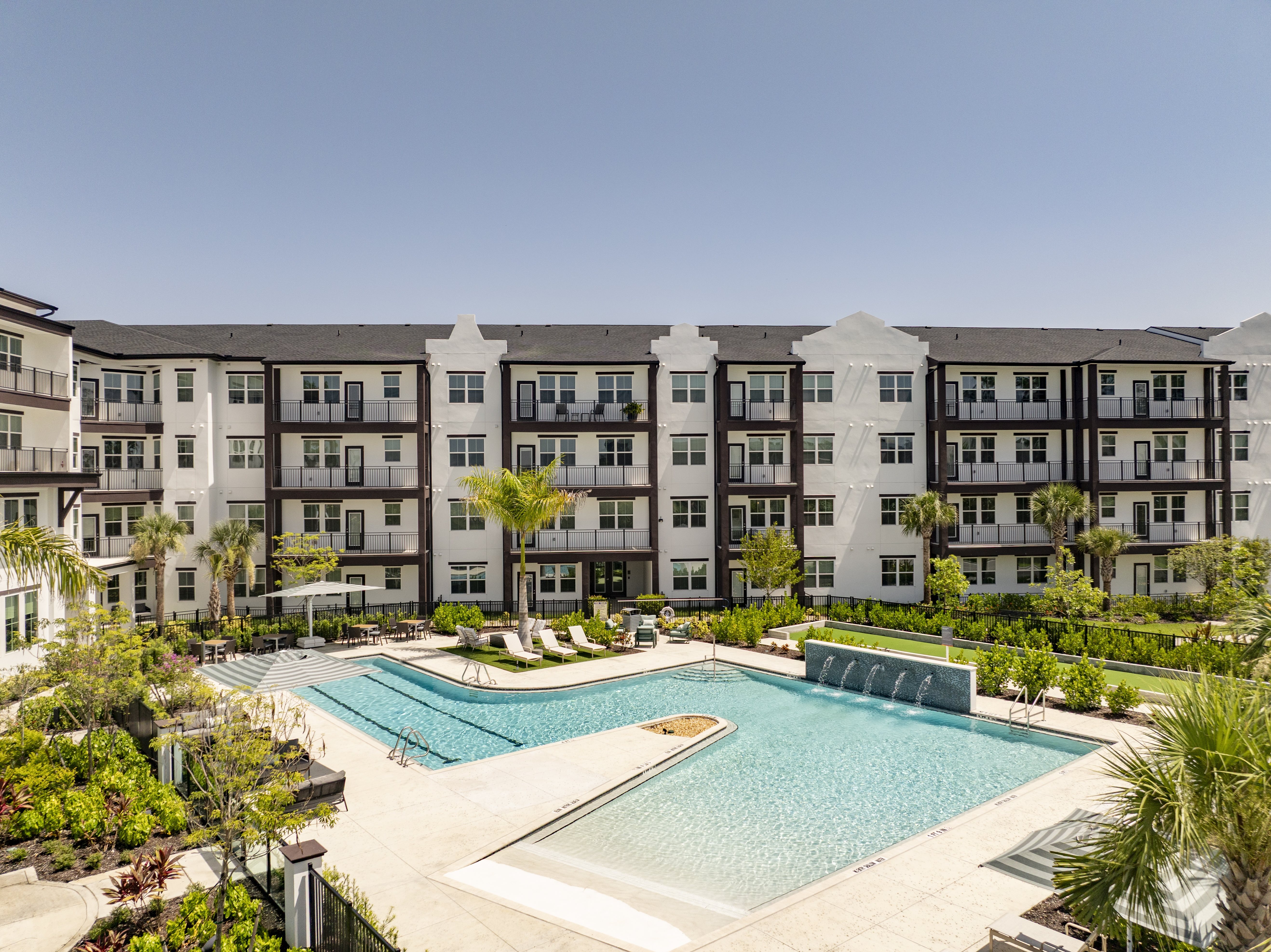 A large swimming pool is surrounded by apartment buildings.