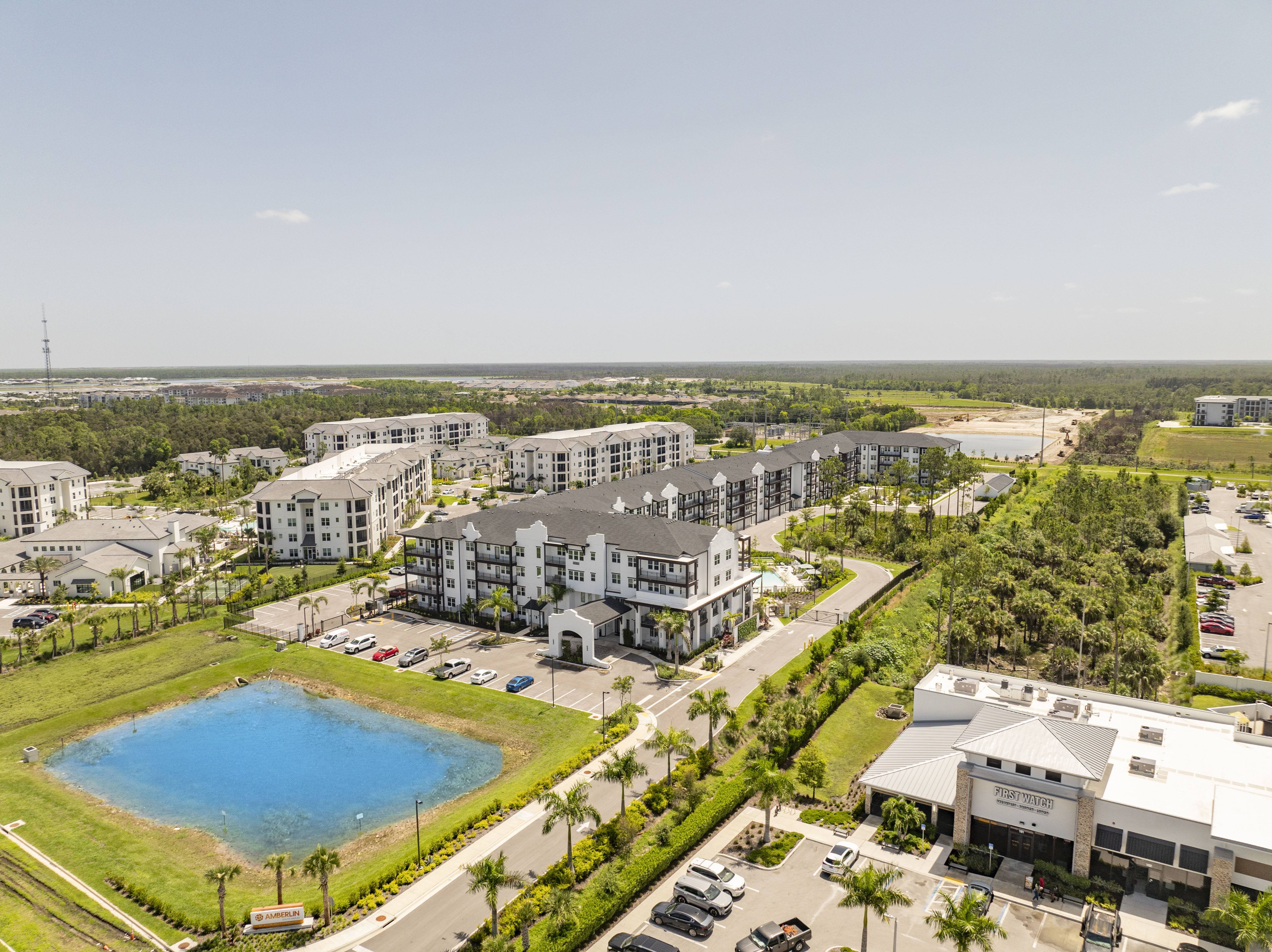 A large white building with a pool in front of it.