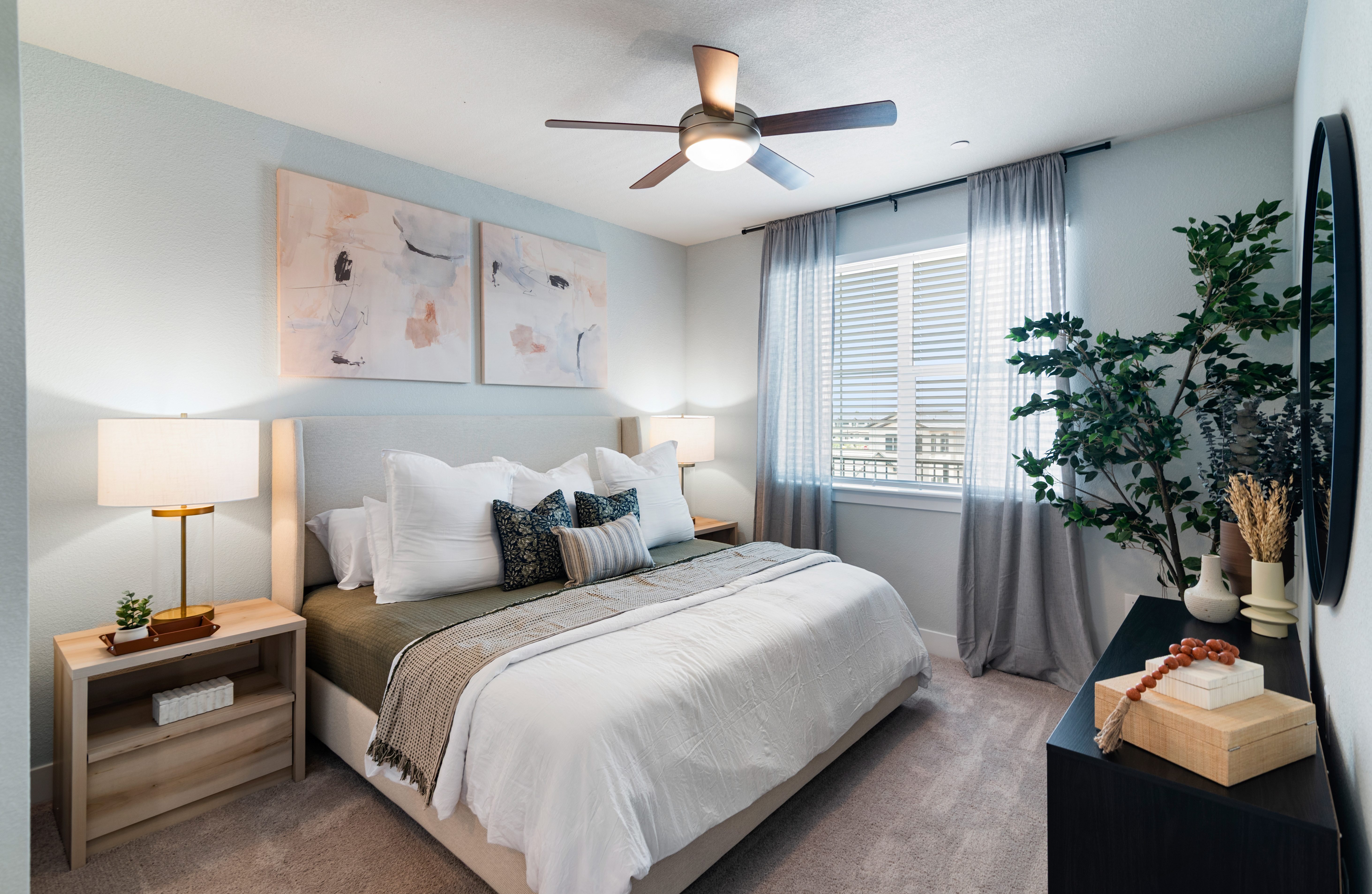 A bedroom with a bed, nightstand, and a ceiling fan.