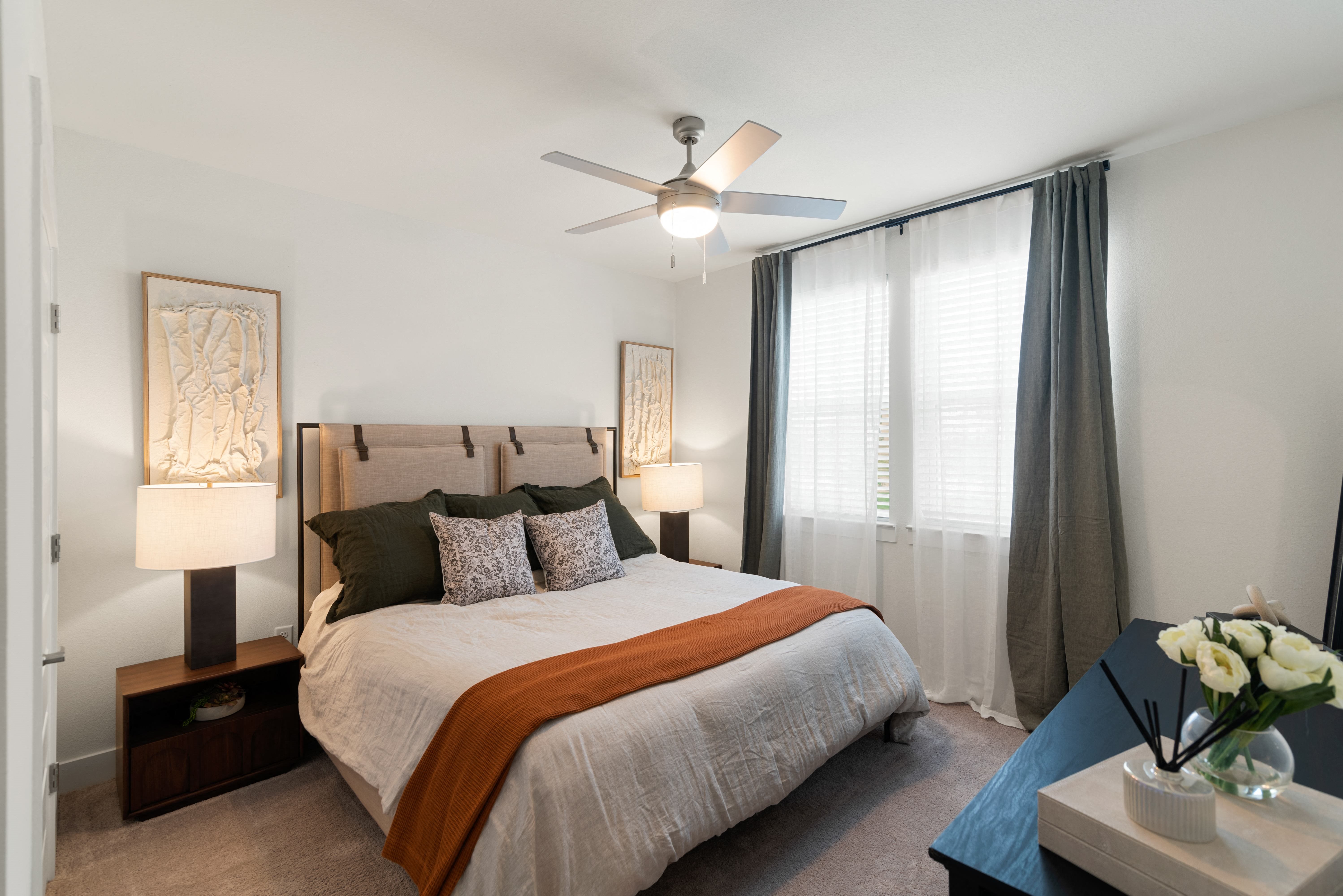 a bedroom with a large bed and a ceiling fan