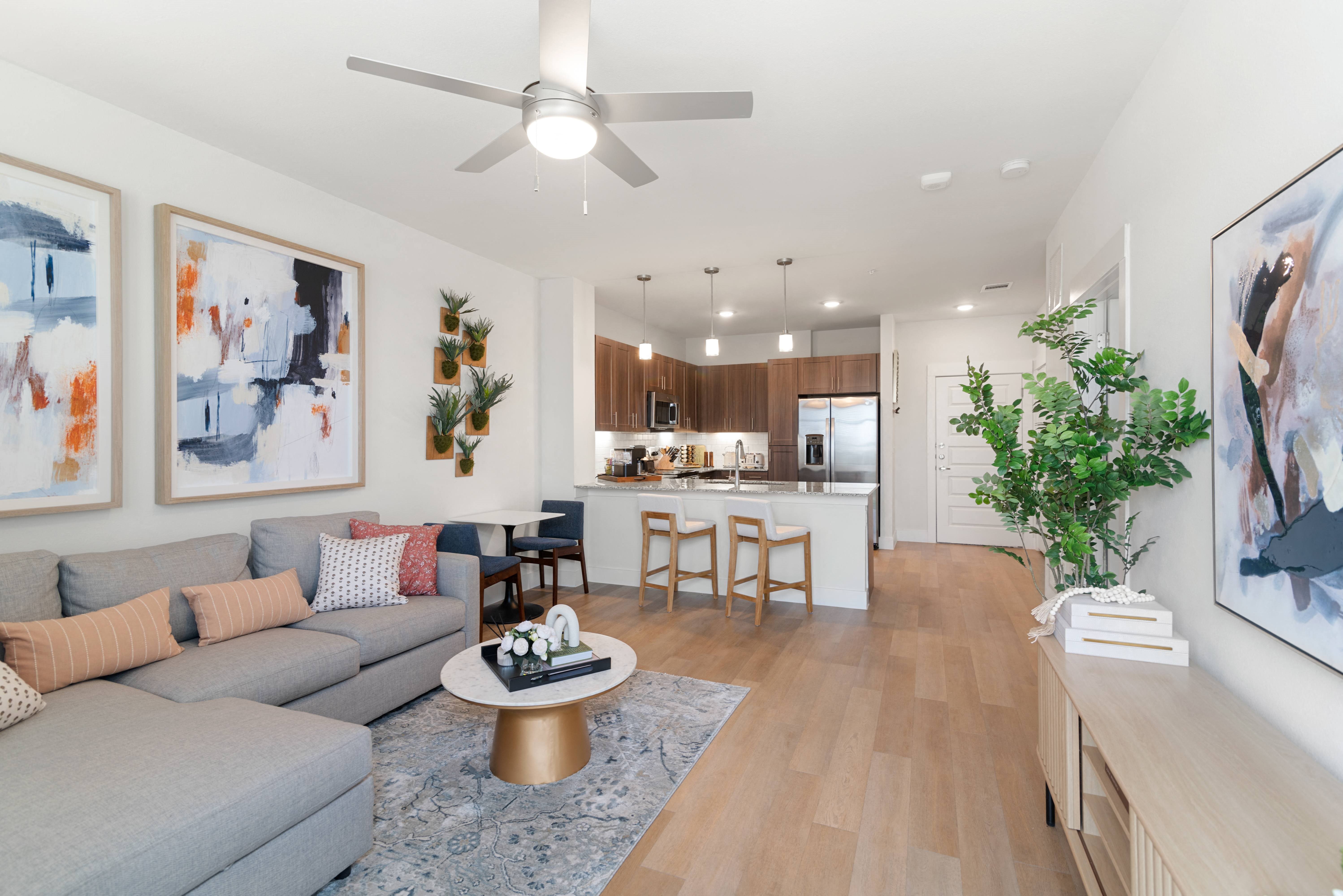 a living room with a couch and a table in front of a kitchen