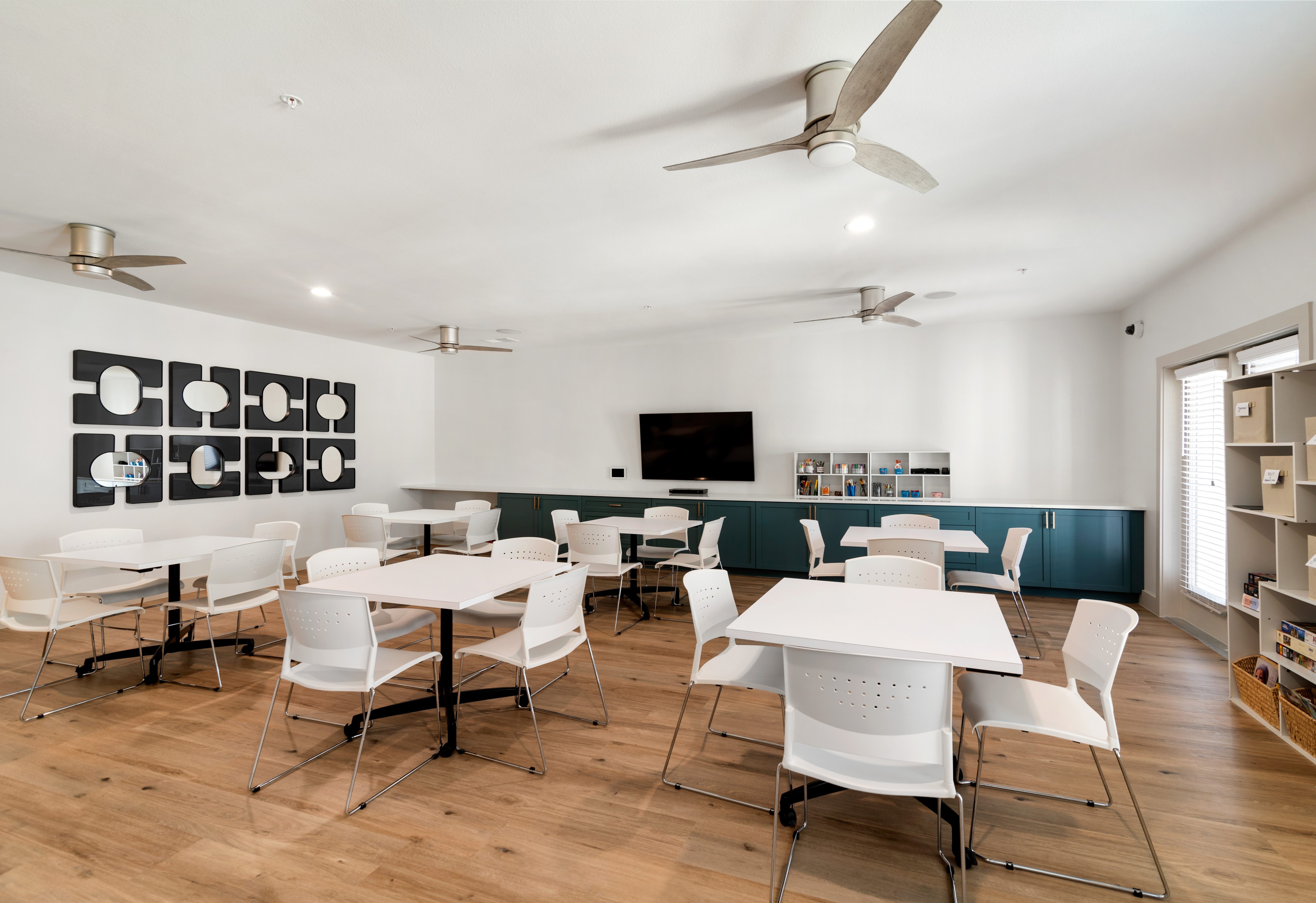 A room with white chairs and tables is shown.
