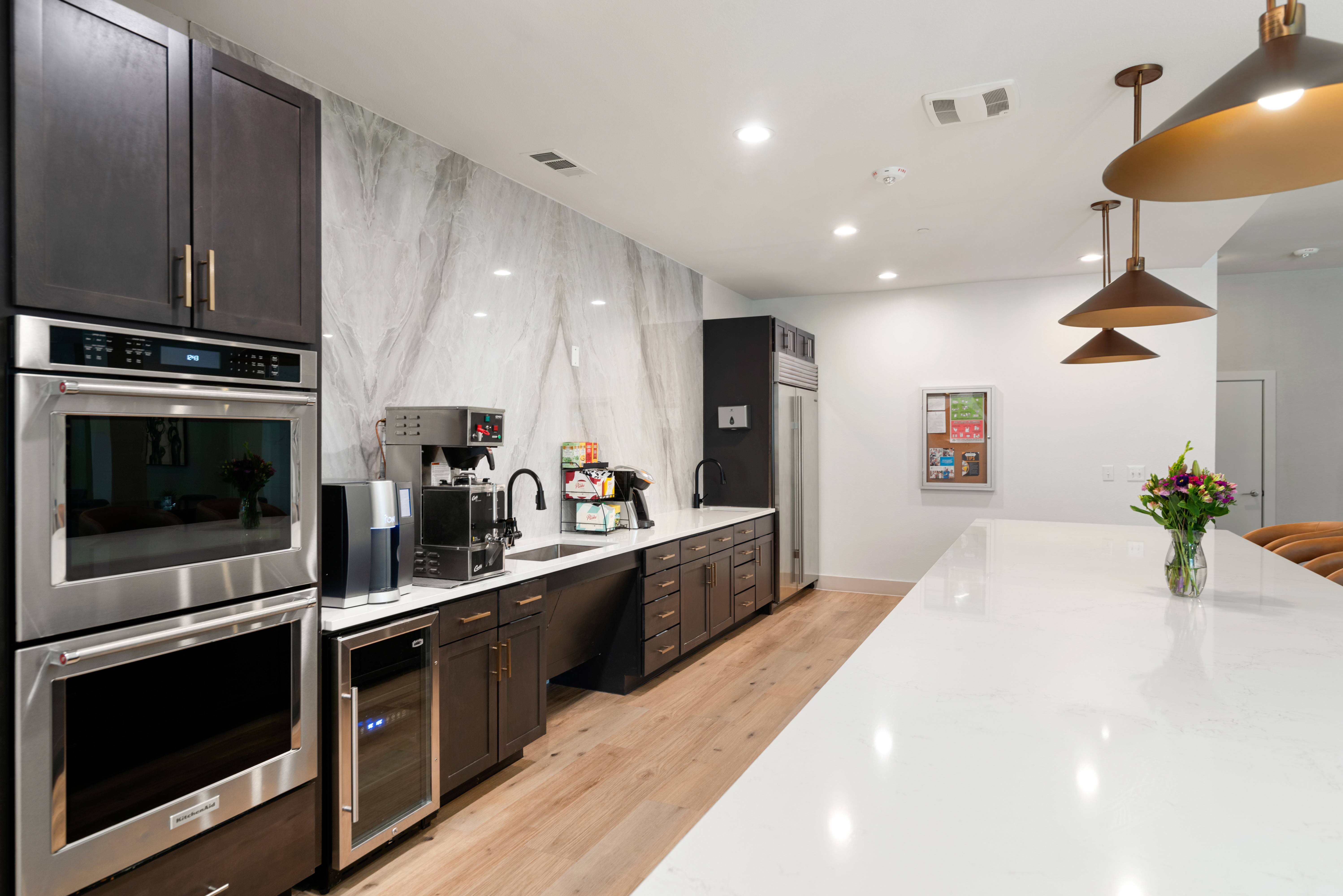 A modern kitchen with dark brown cabinets and stainless steel appliances.