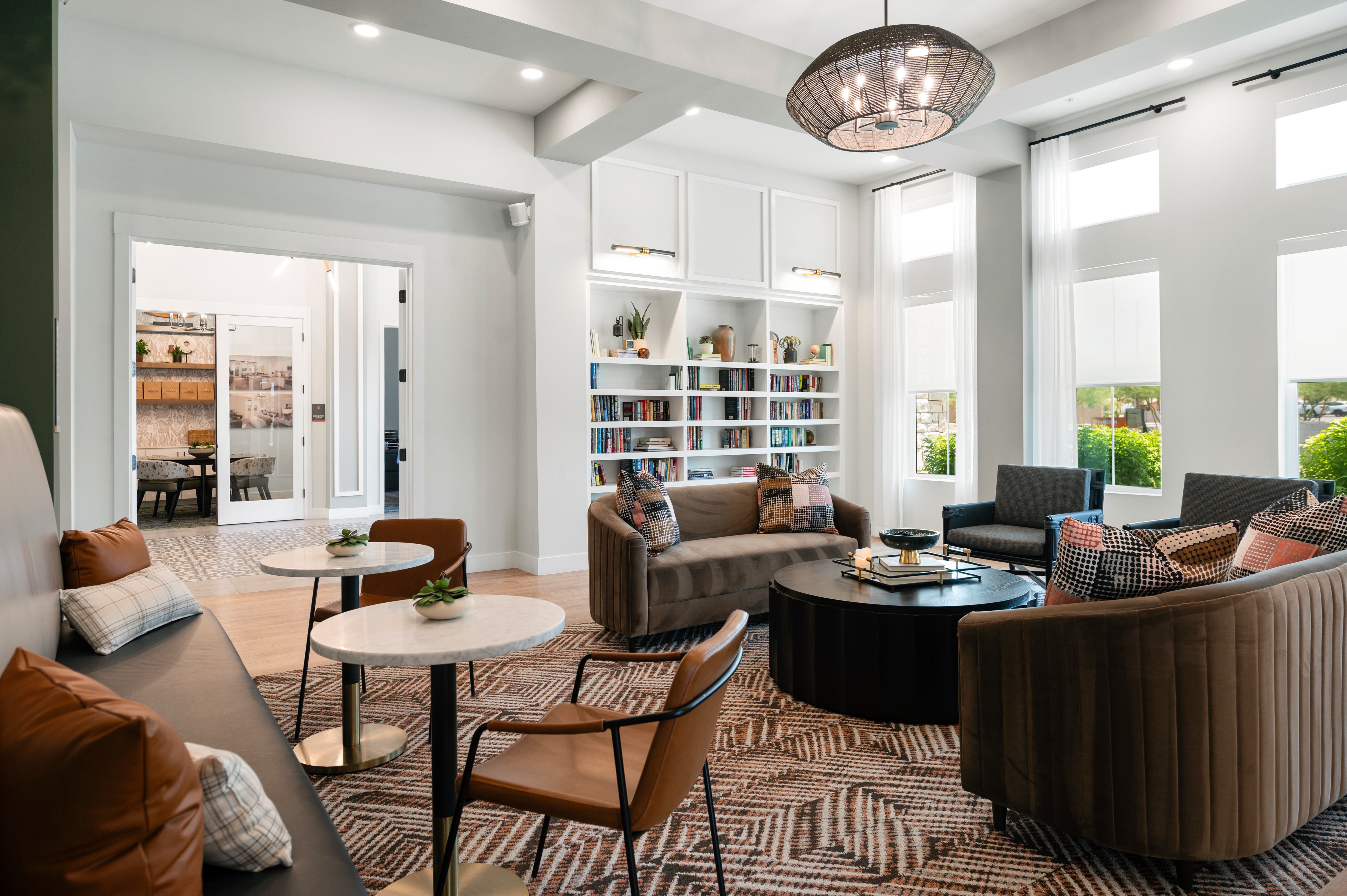 A living room with a white table and brown chairs.