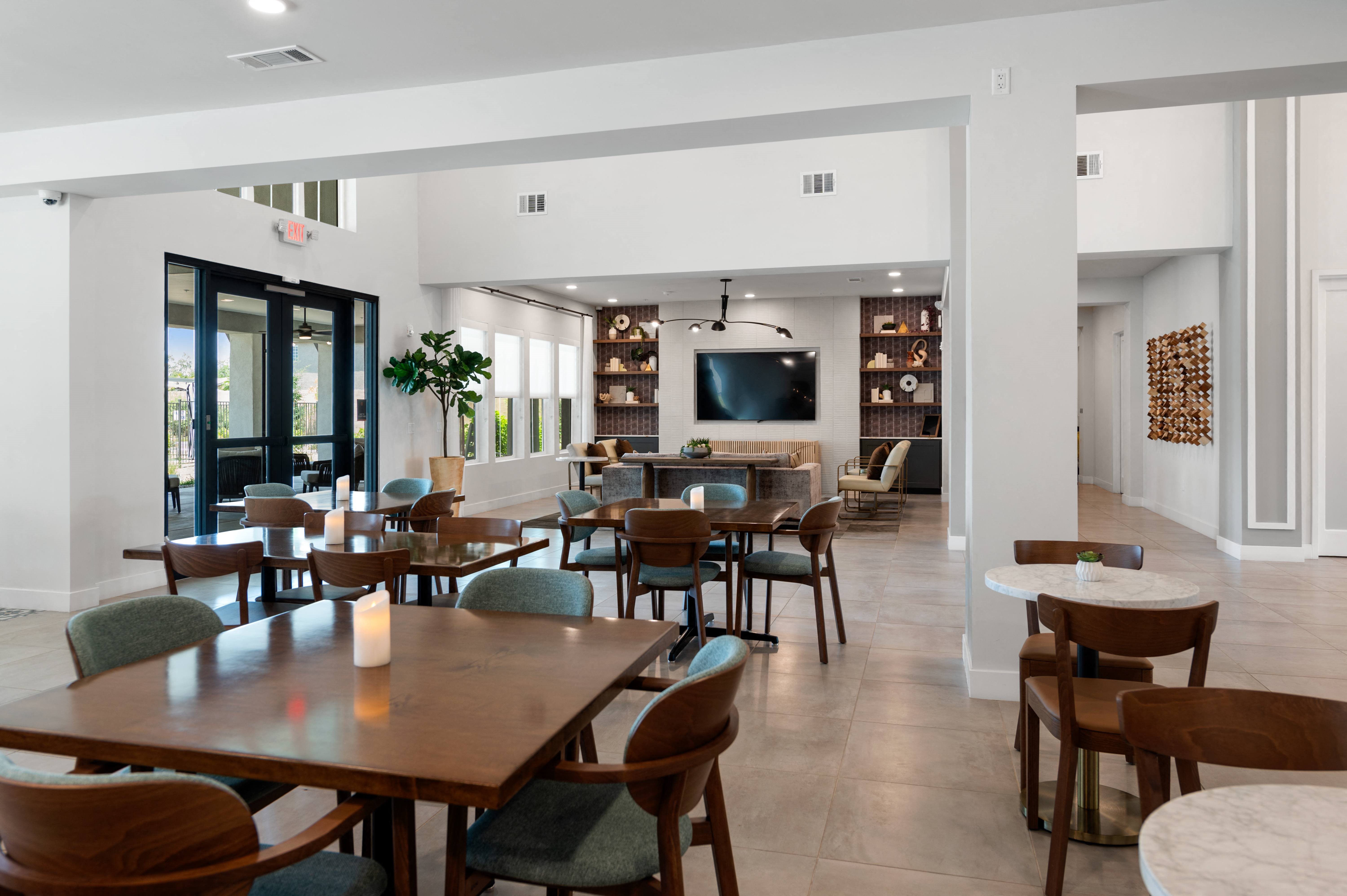 a dining room with tables and chairs and a television