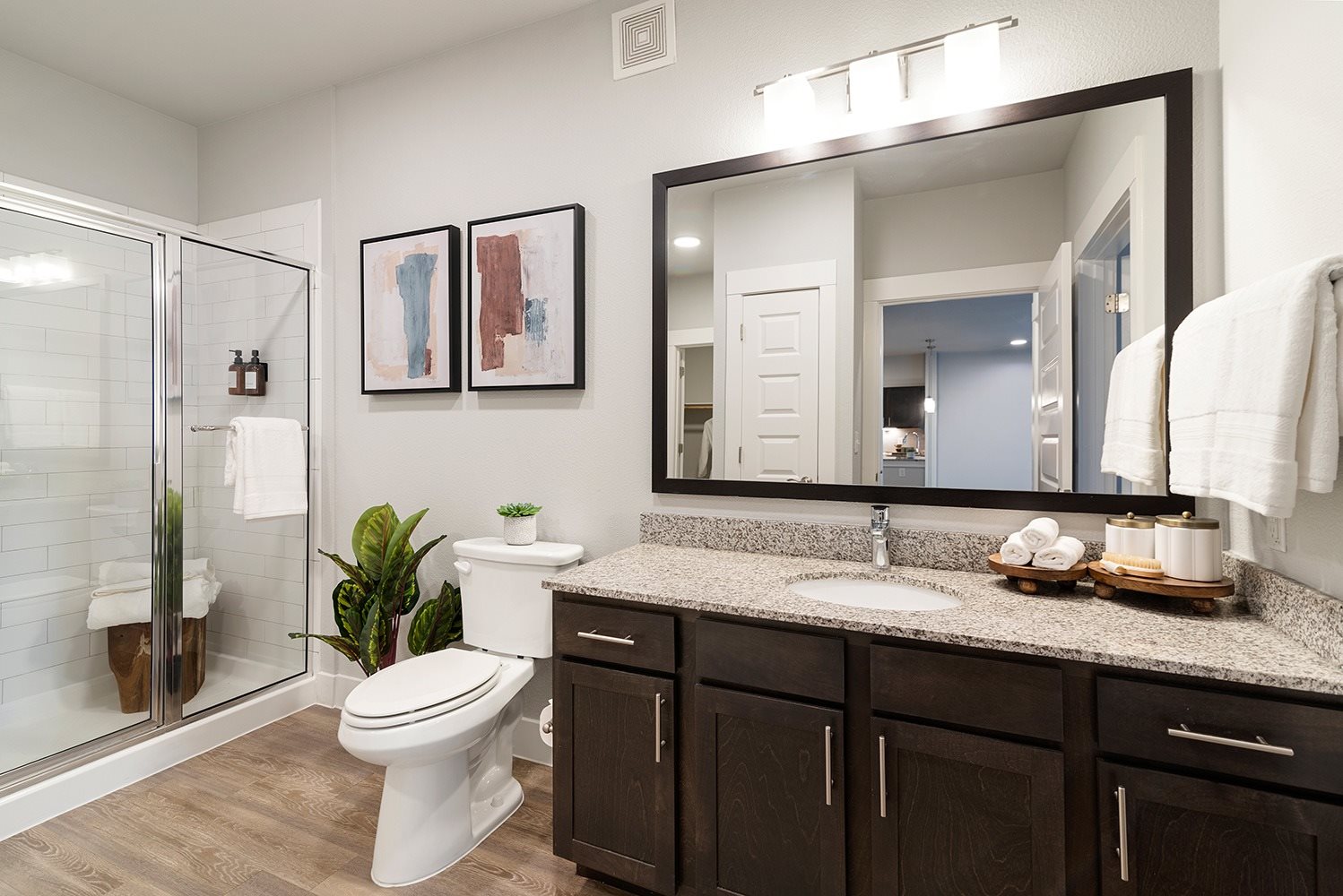 A bathroom with a white toilet and a large mirror.