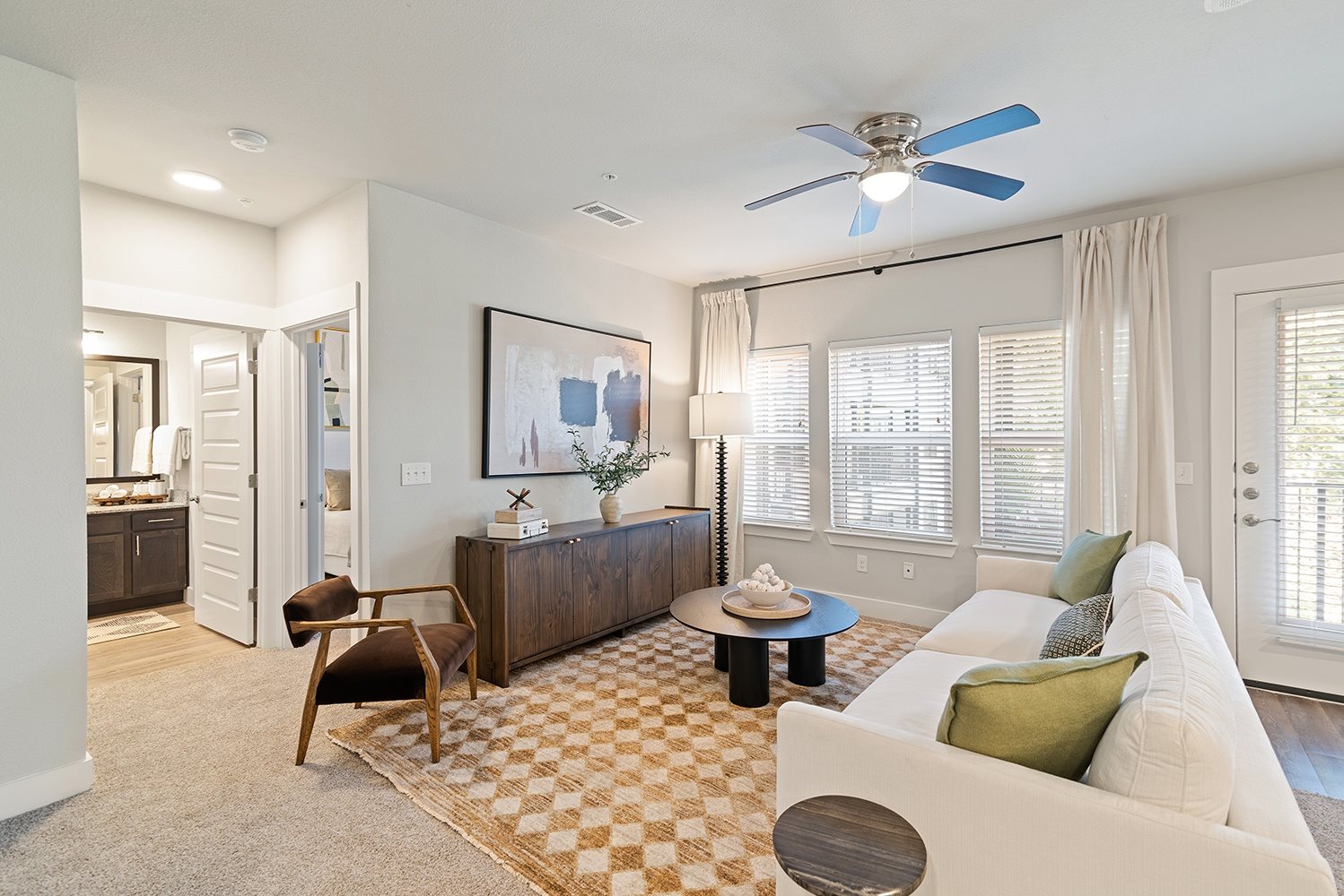A living room with a brown rug and a white couch.