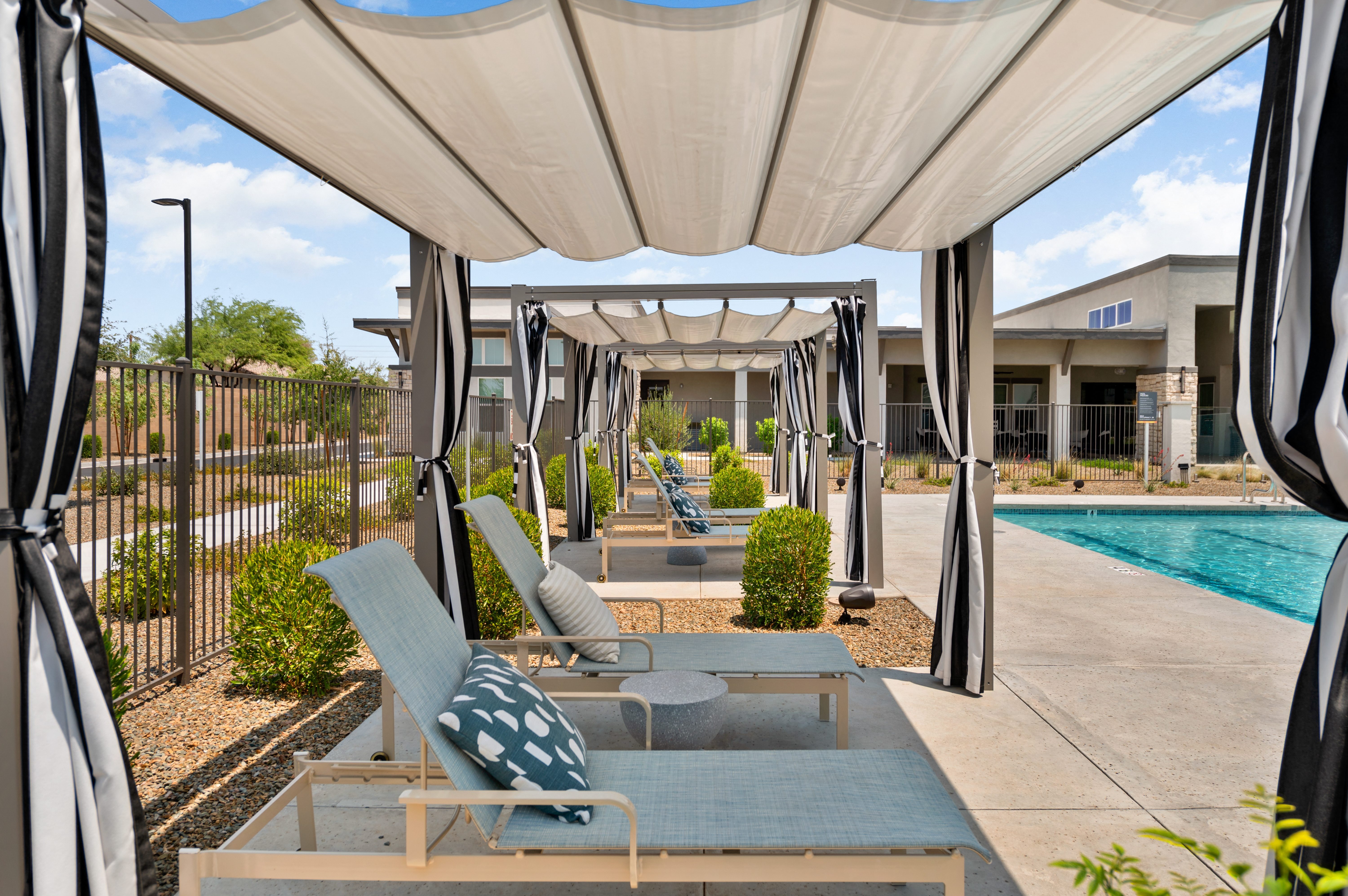 a group of lounge chairs sitting next to a swimming pool