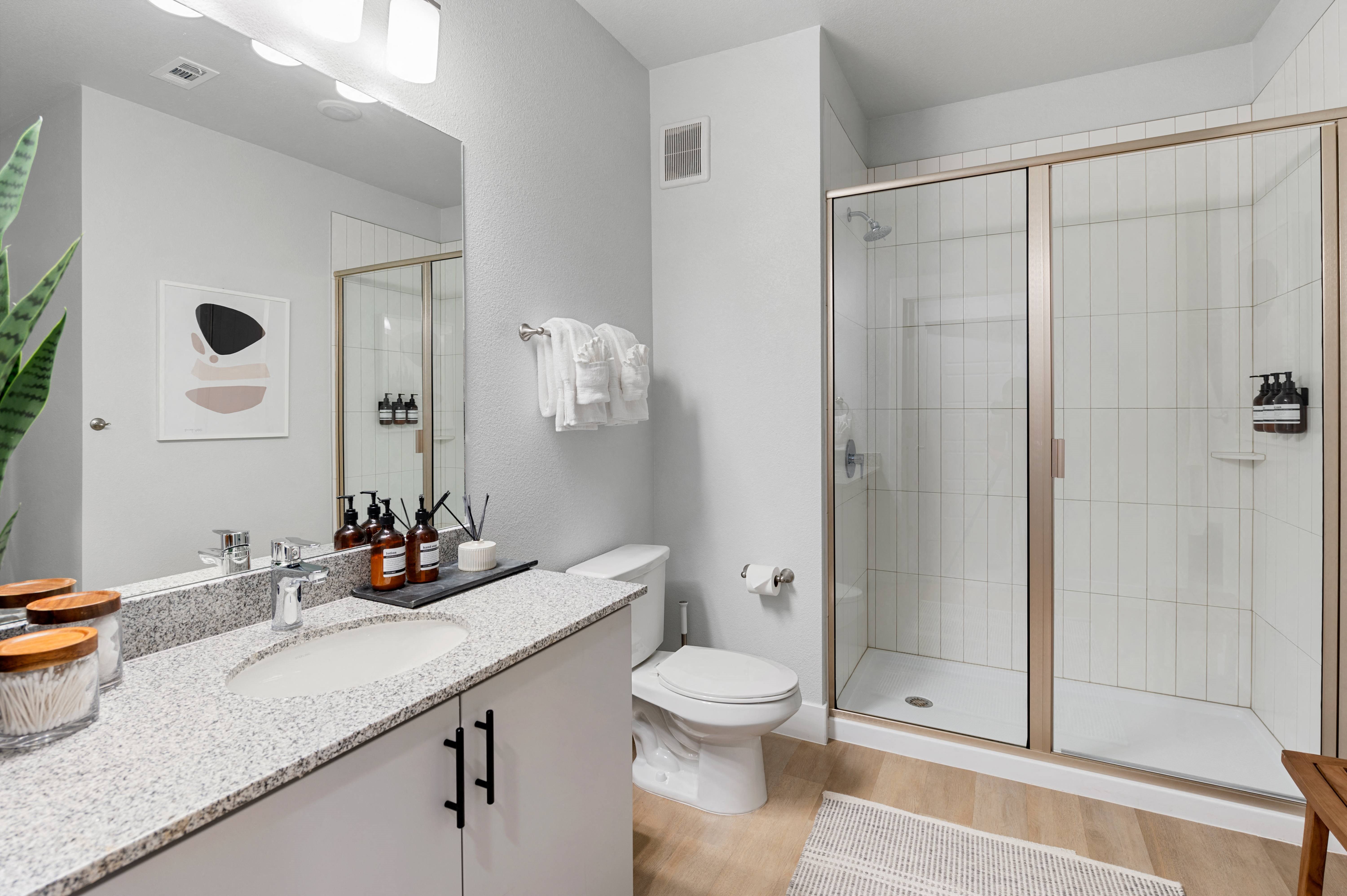 a bathroom with a shower and a sink and a toilet