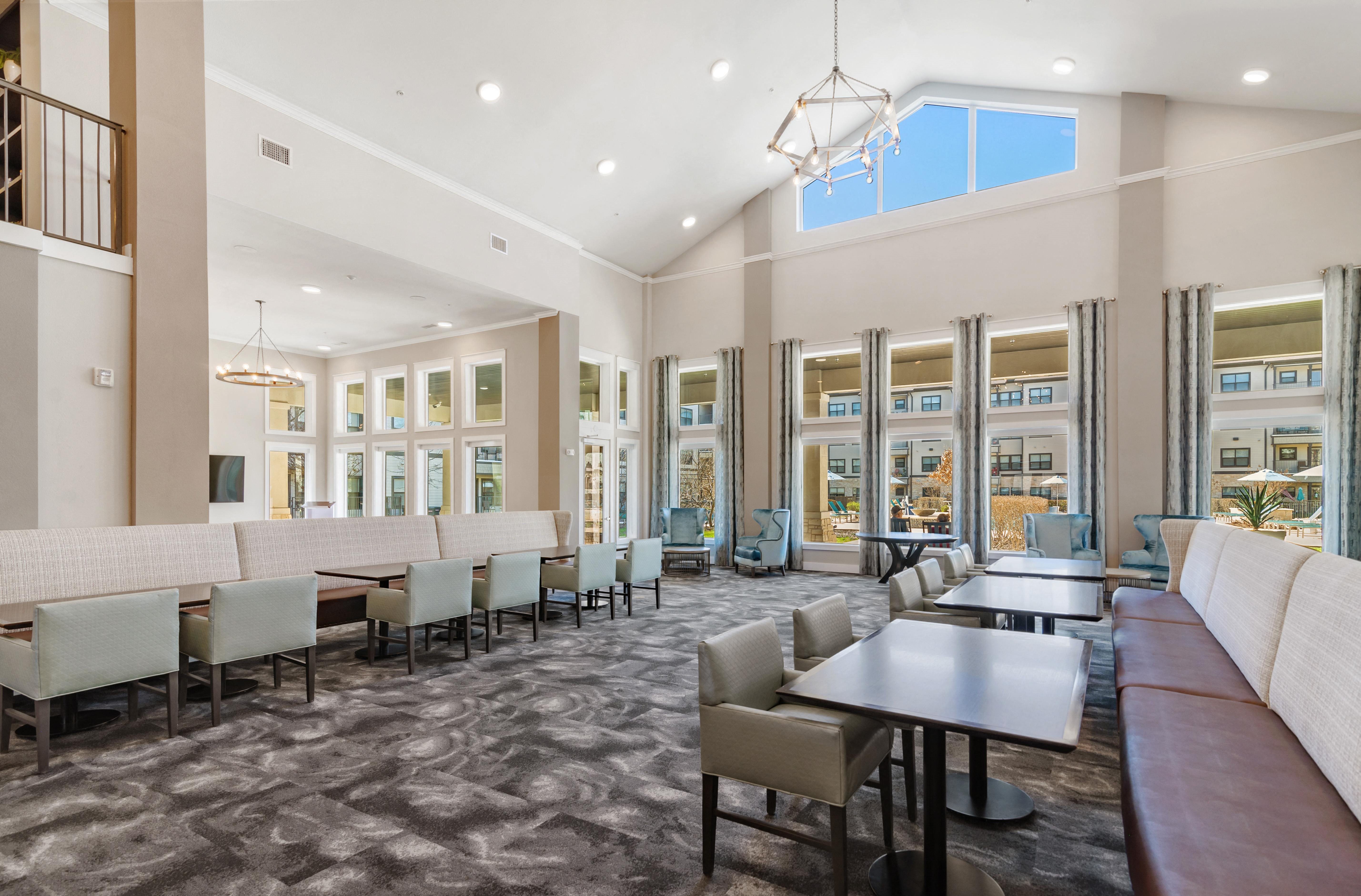 a large communal clubhouse dining area with vaulted ceilings and a chandelier at a senior apartment community